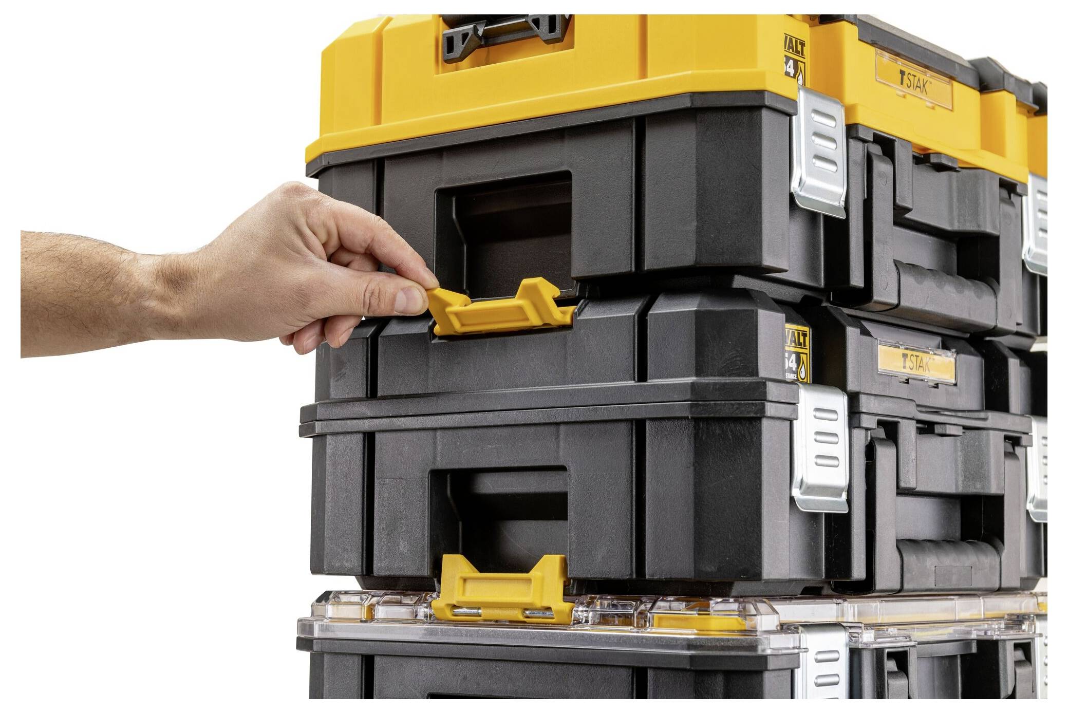 Una mano sta regolando il chiavistello su una pila di cassette portautensili nere e gialle che si incastrano, enfatizzando l'archiviazione sicura e l'organizzazione.