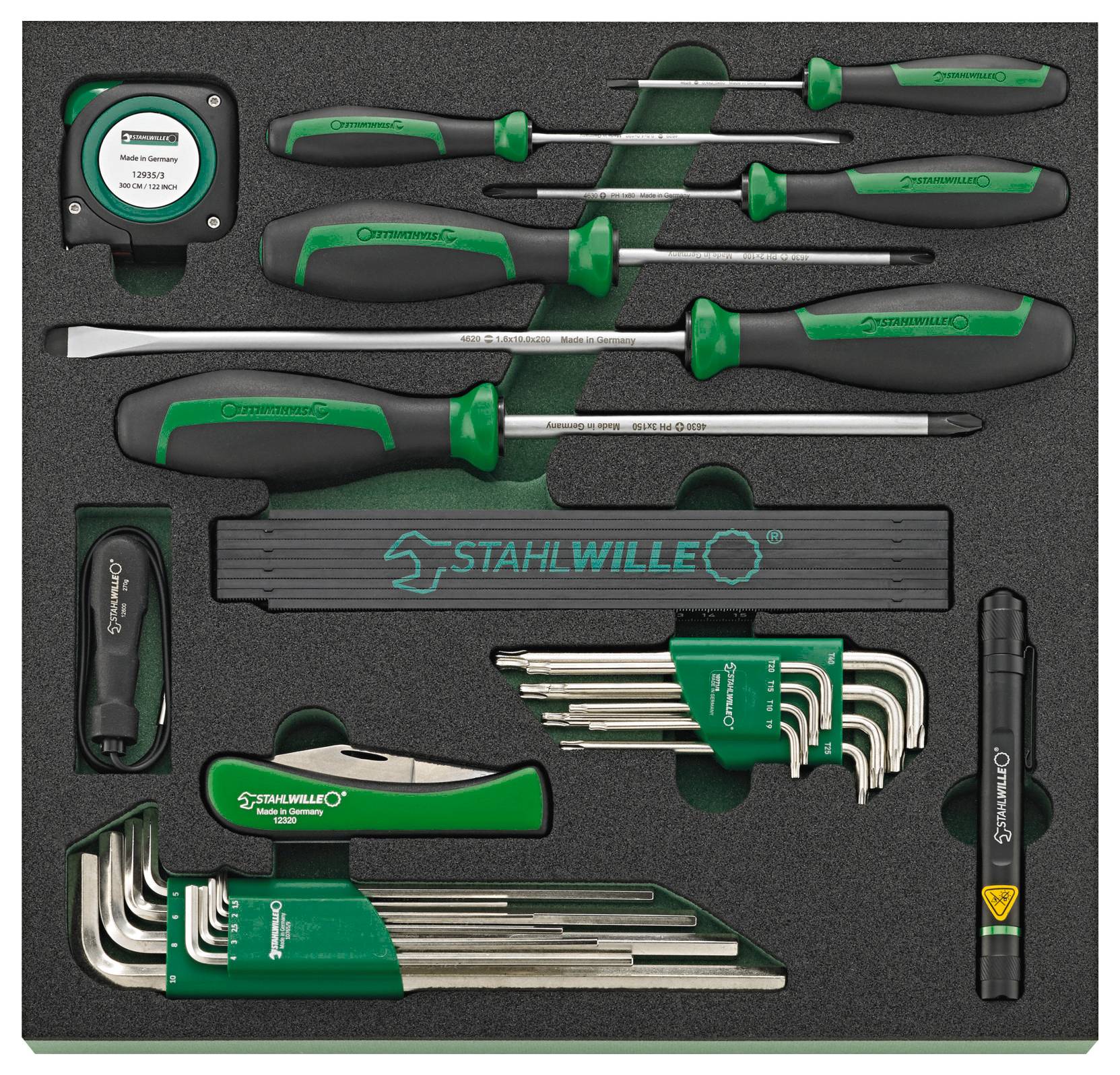 Una cassetta di attrezzi in una custodia in schiuma nera con cacciaviti con manici verdi, un metro a nastro, chiavi esagonali e una pila a forma di penna, etichettata 'STAHLWILLE'.