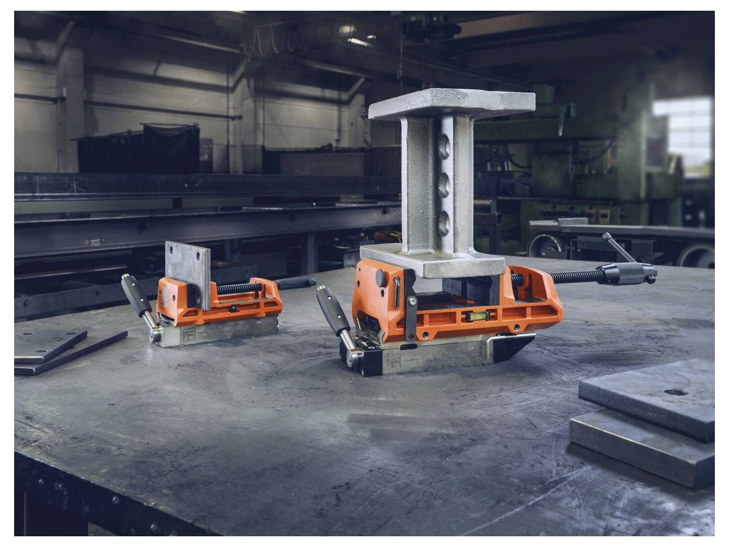 Scena di officina metallurgica che mostra morsetti di saldatura che mantengono i pezzi di metallo saldamente su un banco da lavoro, con attrezzi industriali sullo sfondo.