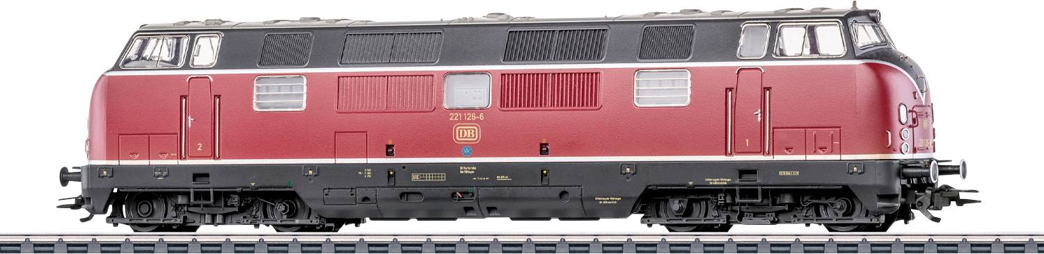 Motore di locomotiva ferroviaria modello rosso su binario espositivo, con design dettagliato, tetto nero e elementi meccanici visibili.