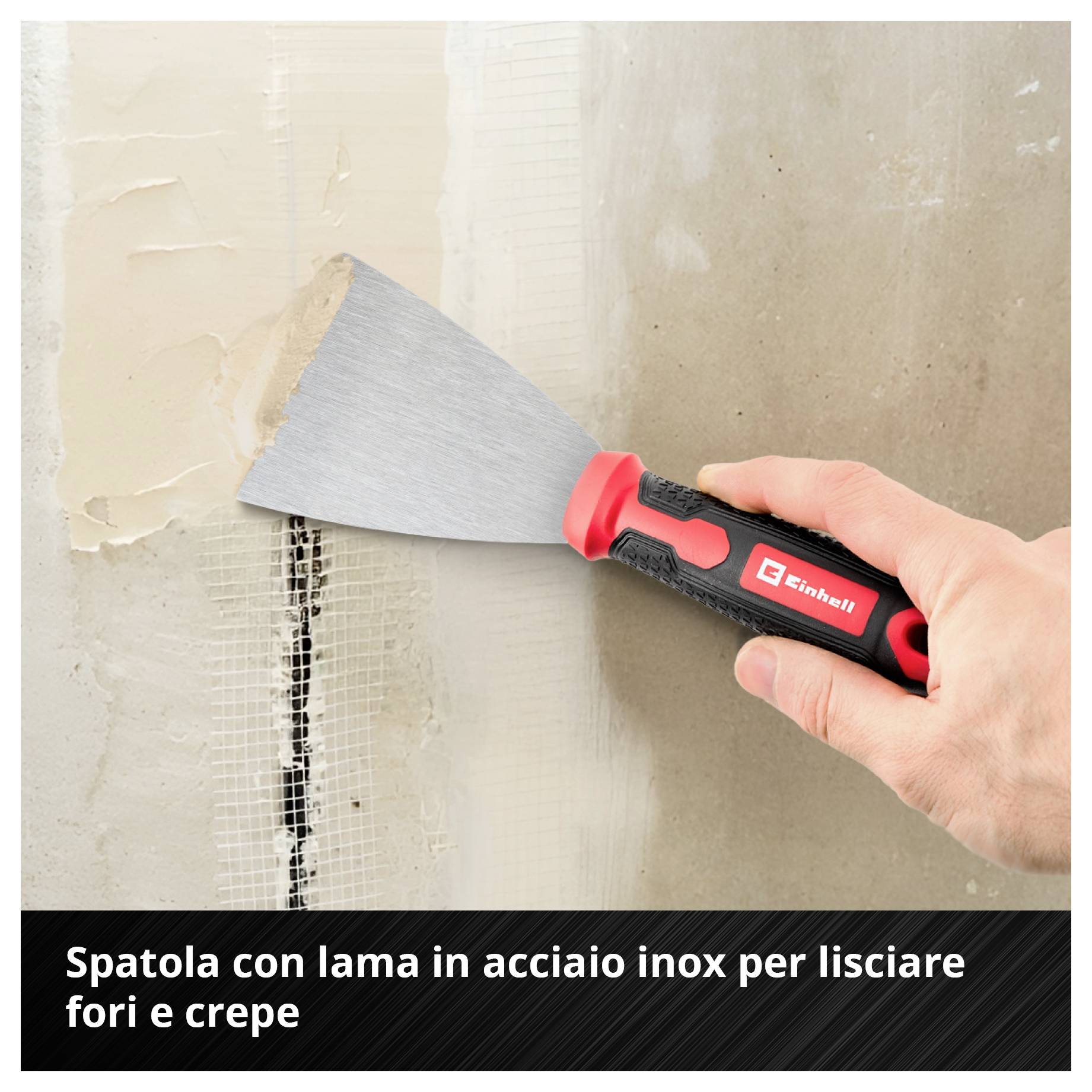 Mano che tiene una spatola con lama in acciaio inossidabile, leviga le crepe nel muro.