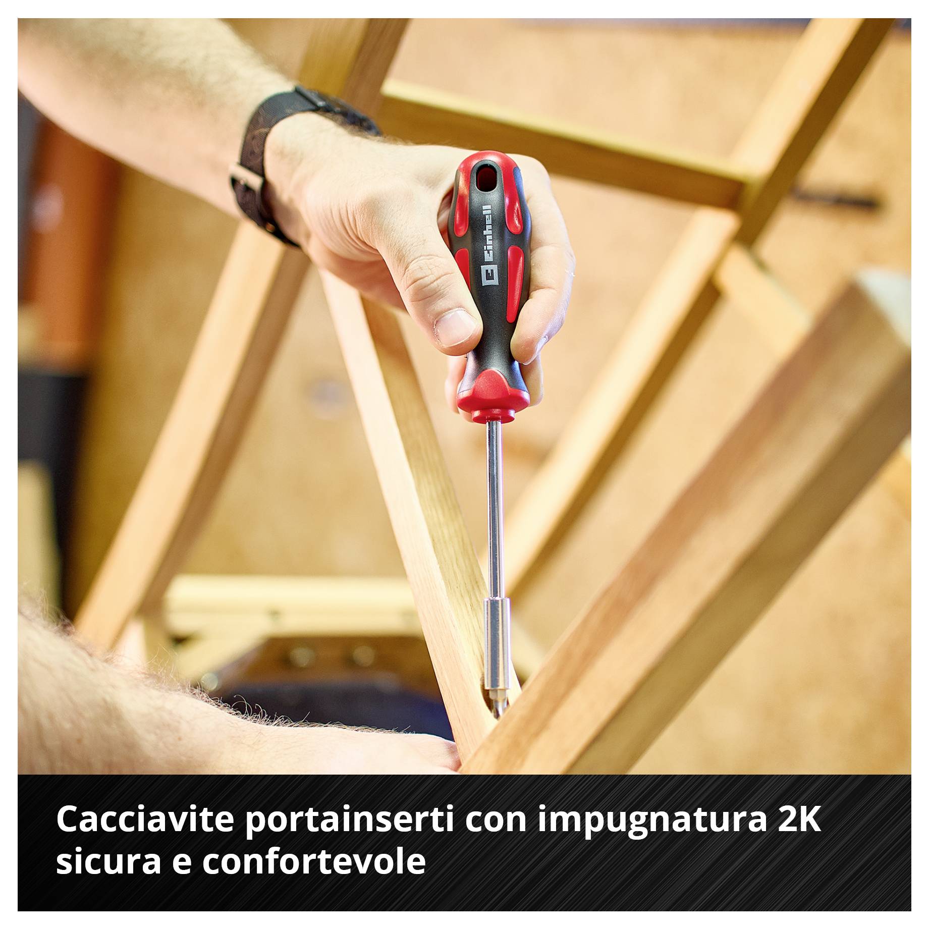 Un cacciavite con bit e impugnatura bicomponente viene utilizzato per avvitare una vite nel legno. Testo: "Il cacciavite con bit e impugnatura bicomponente si tiene saldamente e comodamente in mano".