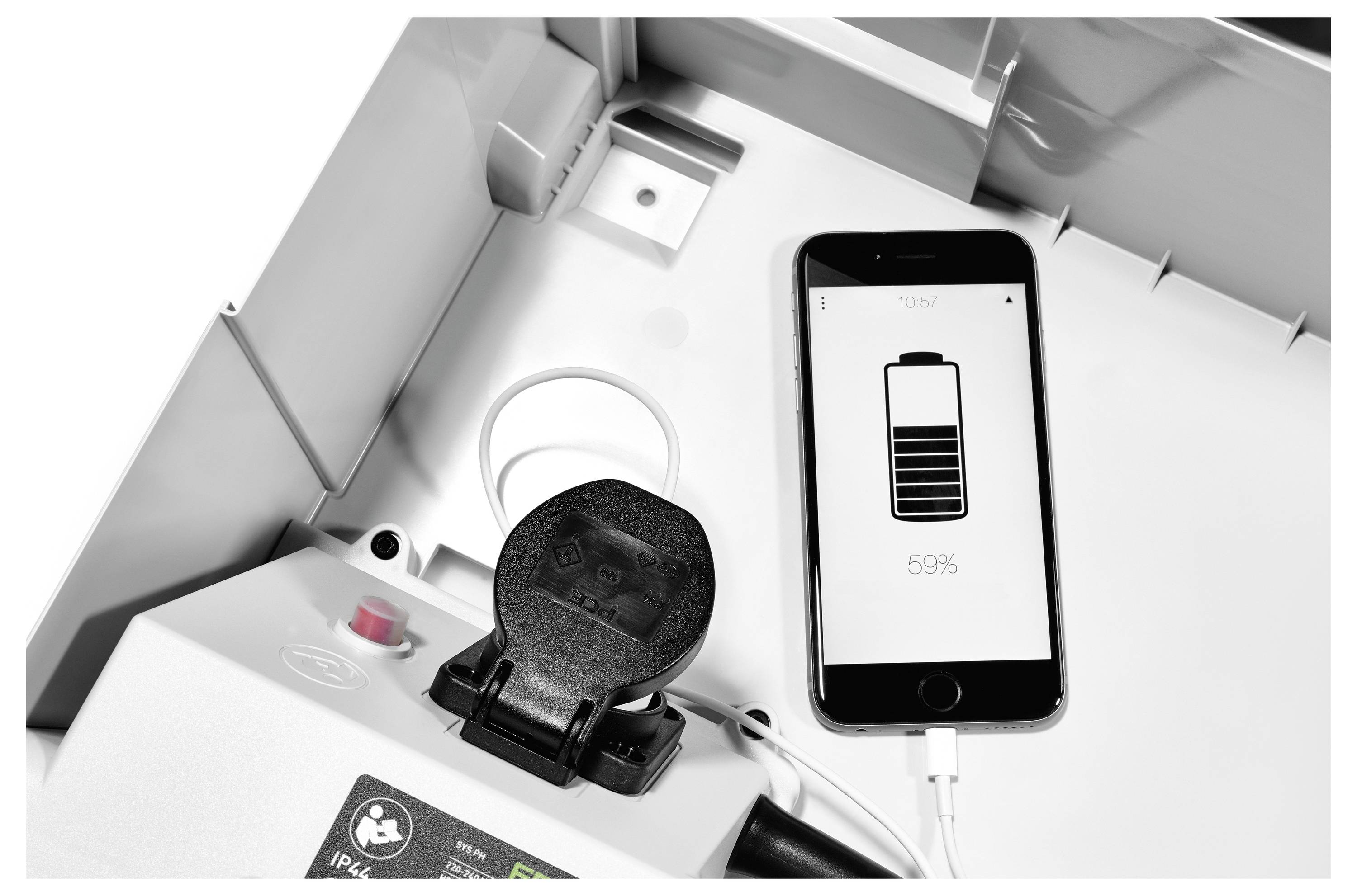 Uno smartphone in carica su un dispositivo con un'icona di batteria visualizzata sullo schermo, indicante il 55% di carica rimanente, accanto a apparecchiature tecniche.