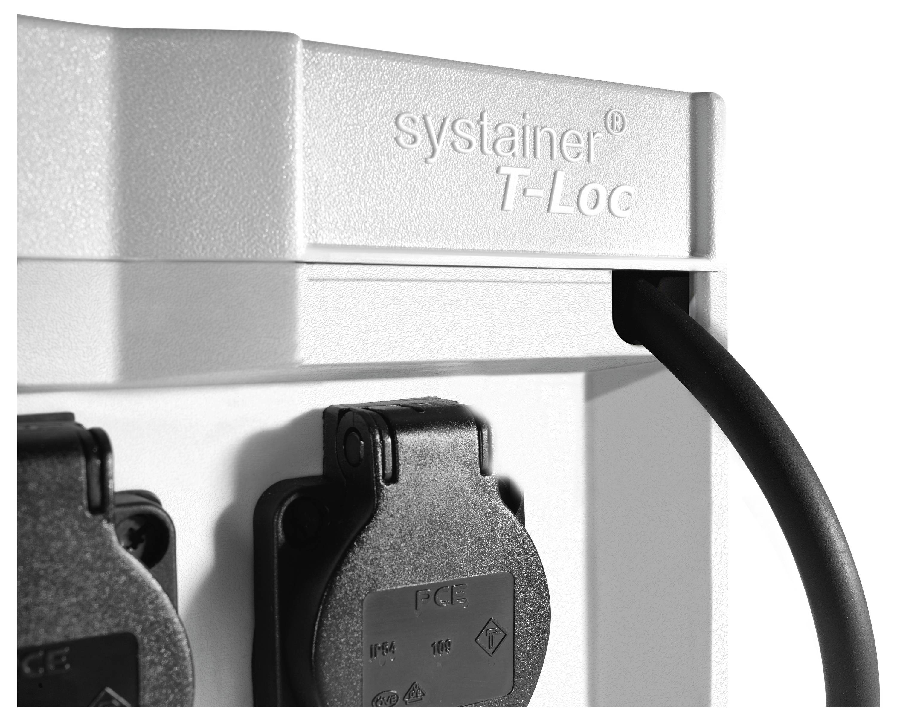 Un primo piano di un pannello di prese elettriche con etichetta 'systainer T-Loc', che mostra due coperture di presa con un cavo collegato a una di esse.