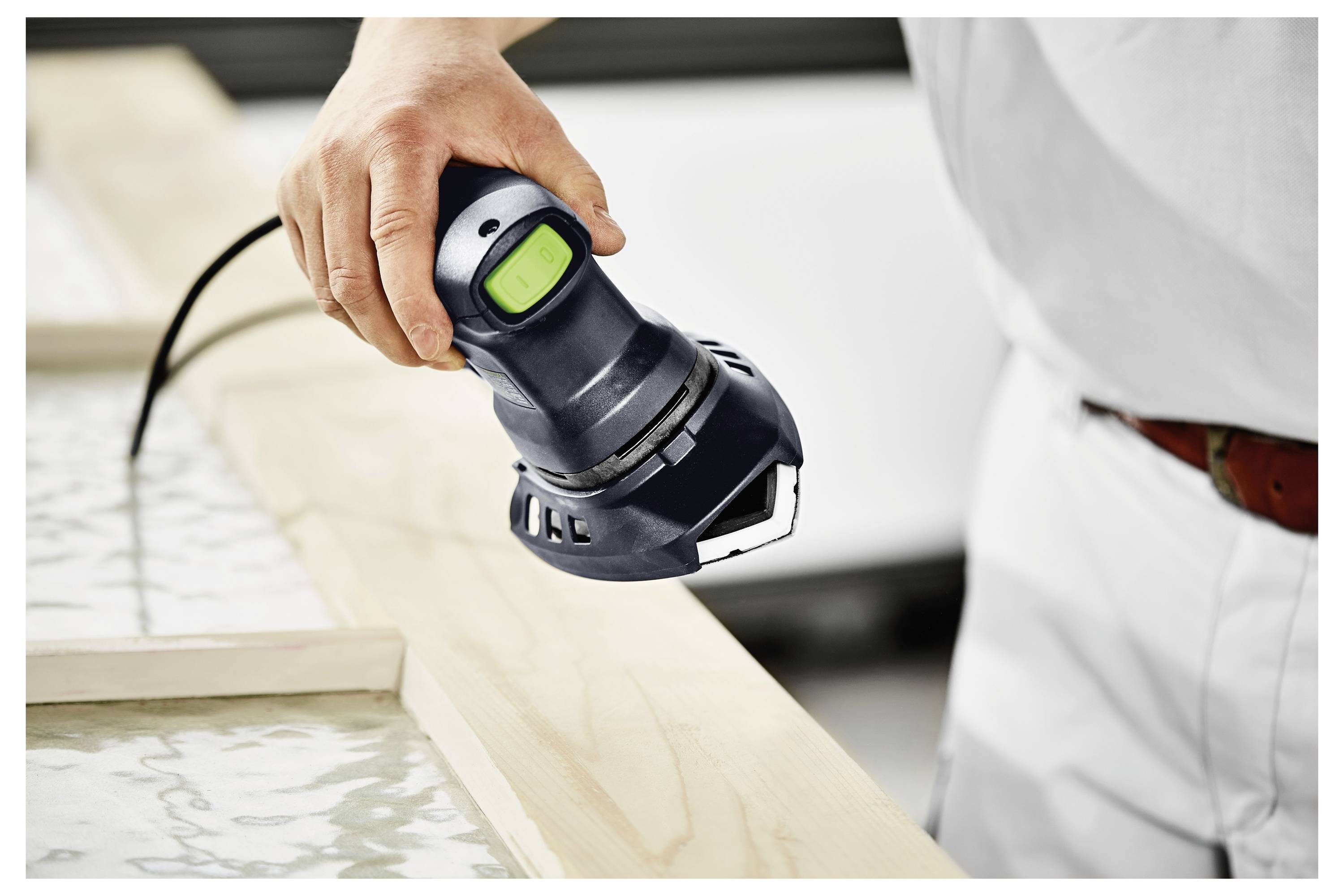 Una persona indossa un maglione grigio e tiene in mano un contenitore trasparente in plastica o un sacchetto. L'attenzione è focalizzata sulla mano e sul contenitore, suggerendo un'attività di imballaggio o trasloco.