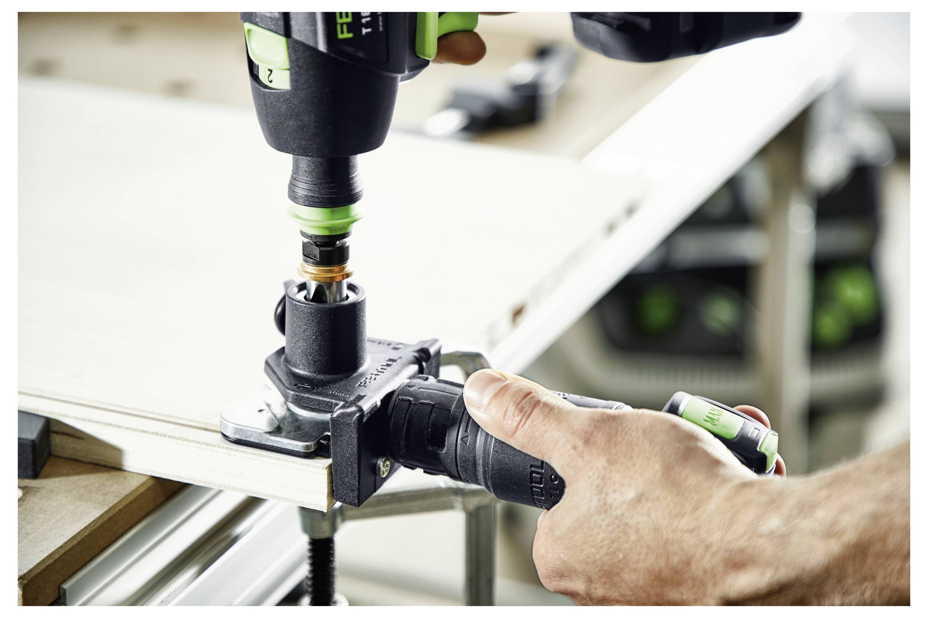 Una persona utilizza un trapano con un accessorio circolare su un pezzo di legno, fissato da una morsa. L'attenzione è focalizzata sul processo di lavorazione del legno.