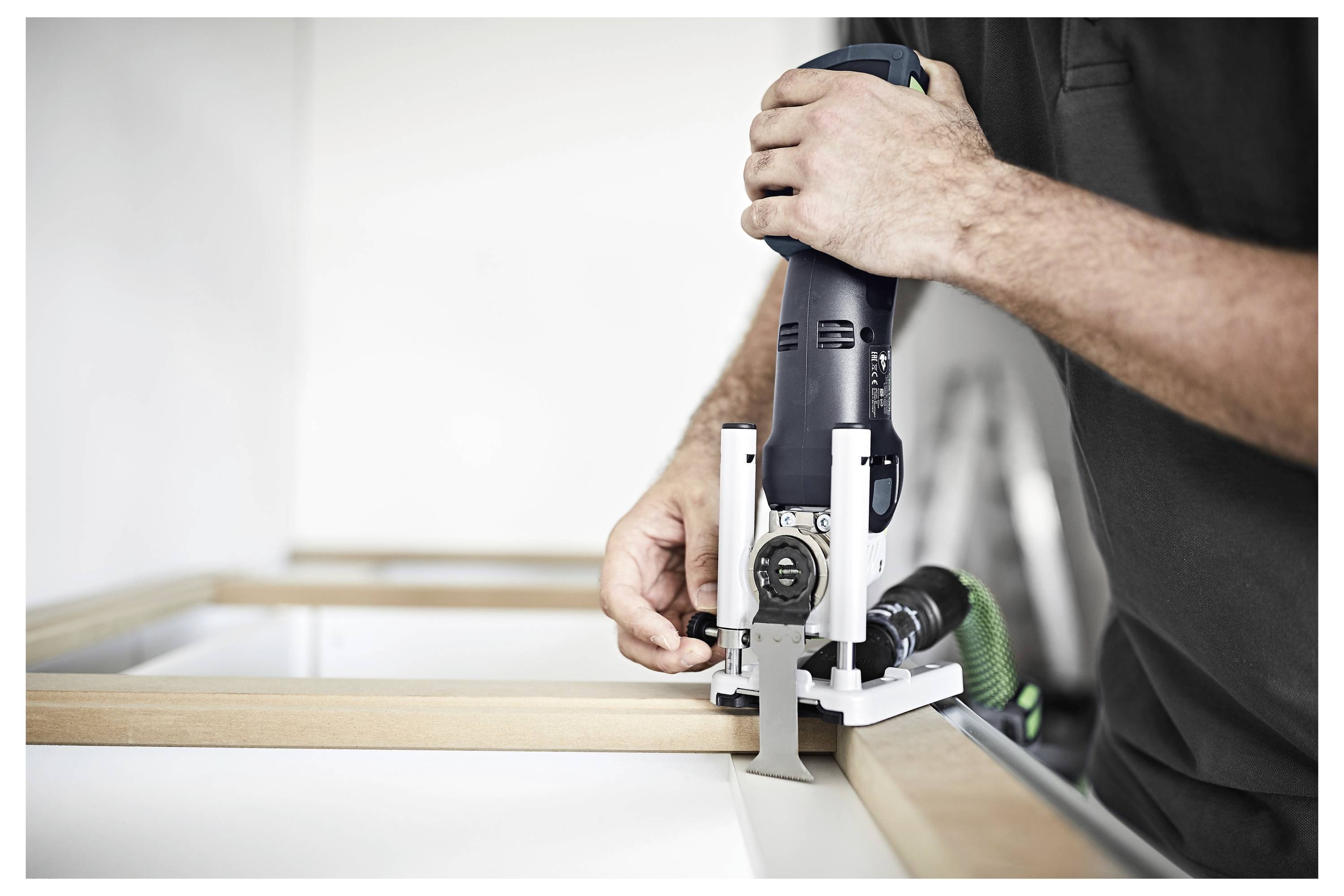 Una persona utilizza una levigatrice elettrica su una superficie di legno, levigandola con un disco di carta vetrata blu.