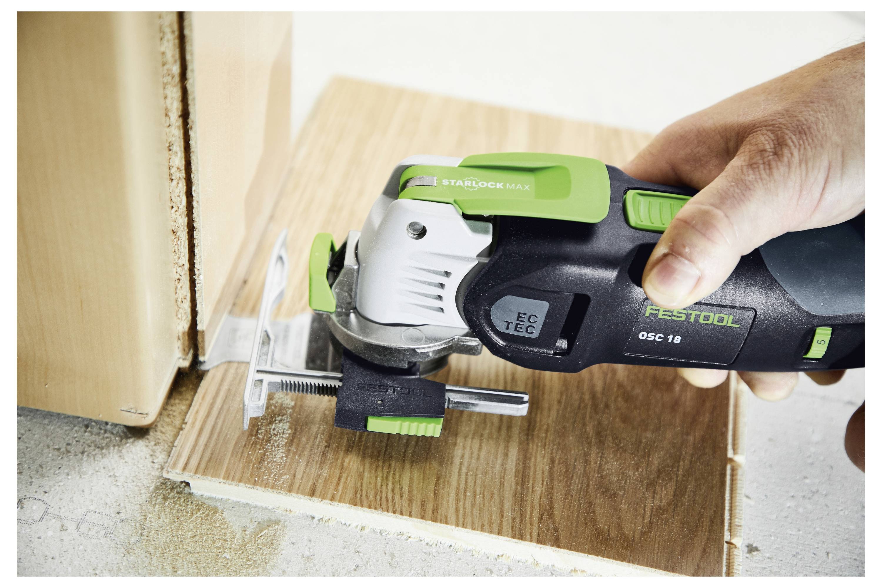 Una persona utilizza una sega senza fili Festool per tagliare un pannello di legno. La sega è posizionata al bordo del pannello, mostrando precisione e dettaglio.