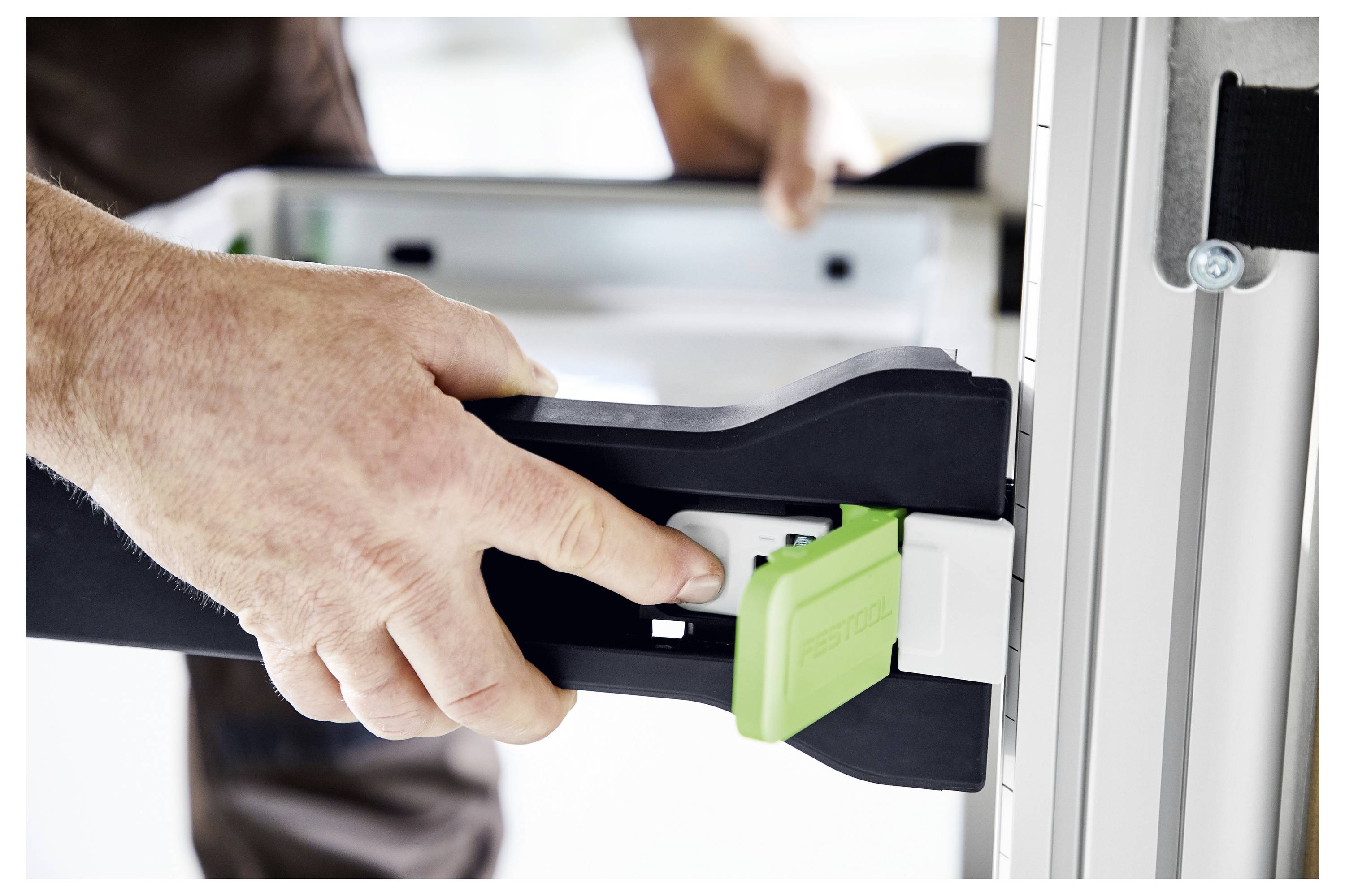 Primo piano di una mano che regola una morsa su una struttura metallica, dimostrando la gestione precisa degli attrezzi per la costruzione o l'assemblaggio.