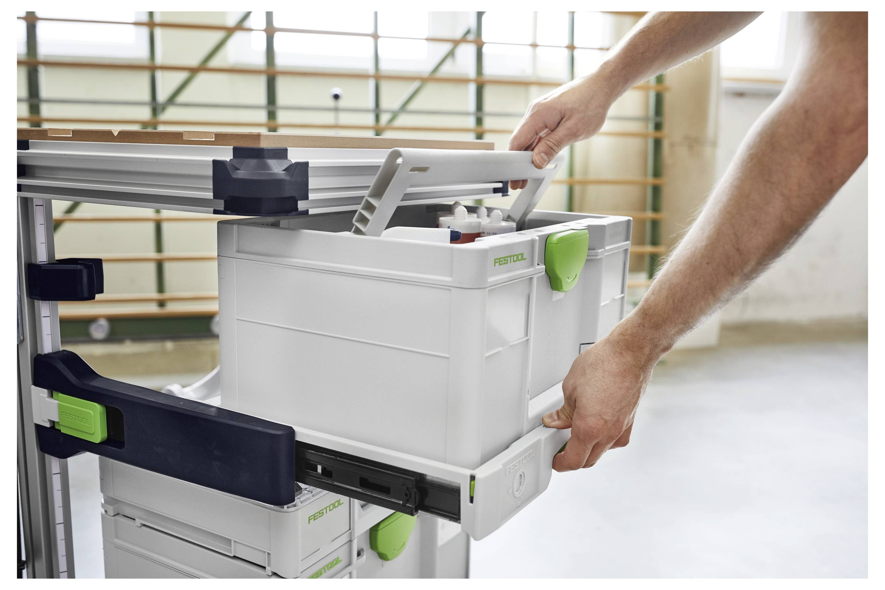 Router 'Festool OF 1010 EQ' su un banco da lavoro, che taglia giunti a coda di rondine precisi in pezzi di legno, circondato da attrezzi da falegnameria.