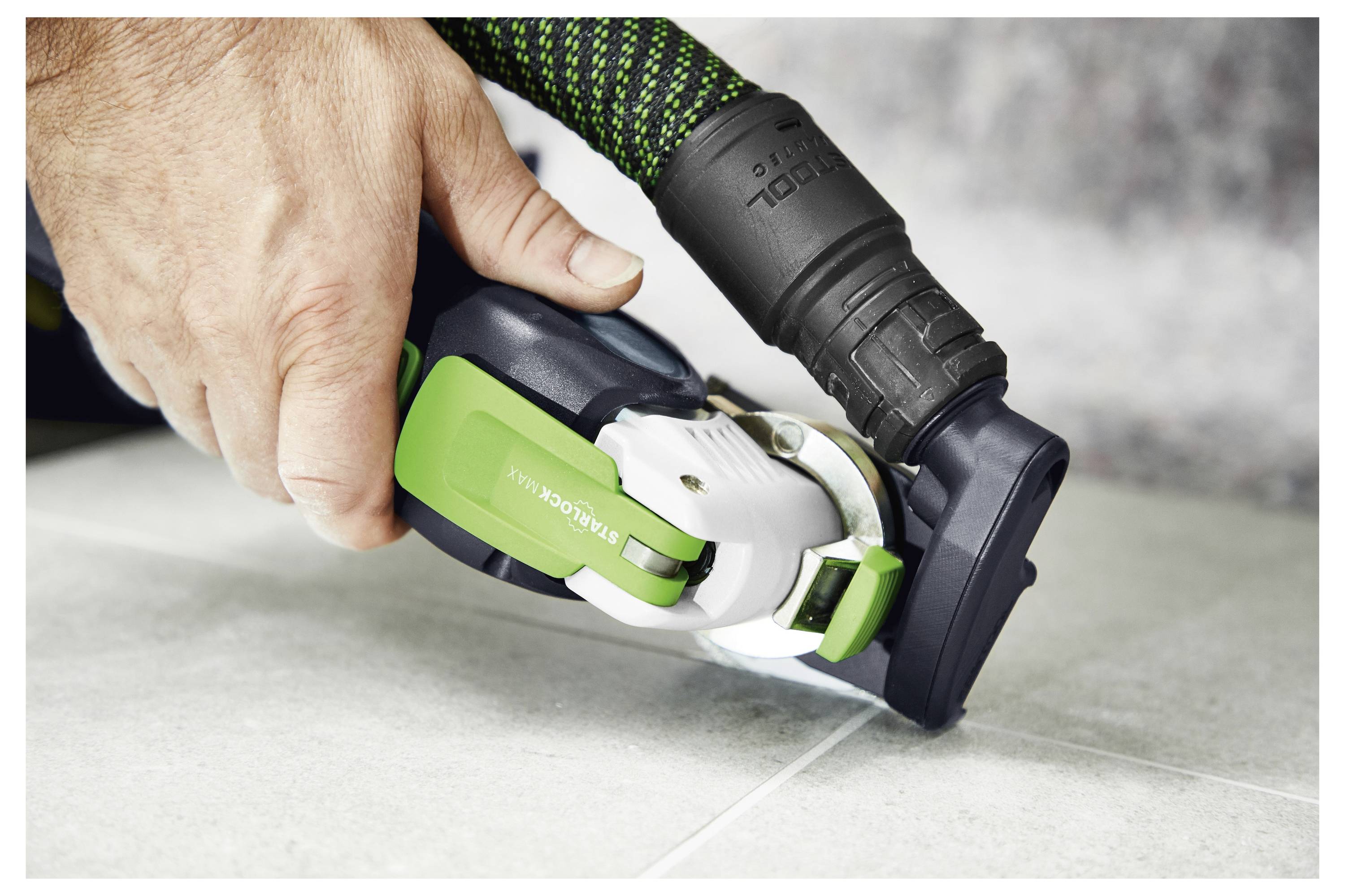 Una persona utilizza un attrezzo elettrico portatile Festool OSC 18 per tagliare il legno, dimostrando un lavoro di precisione su un progetto di miglioramento della casa.