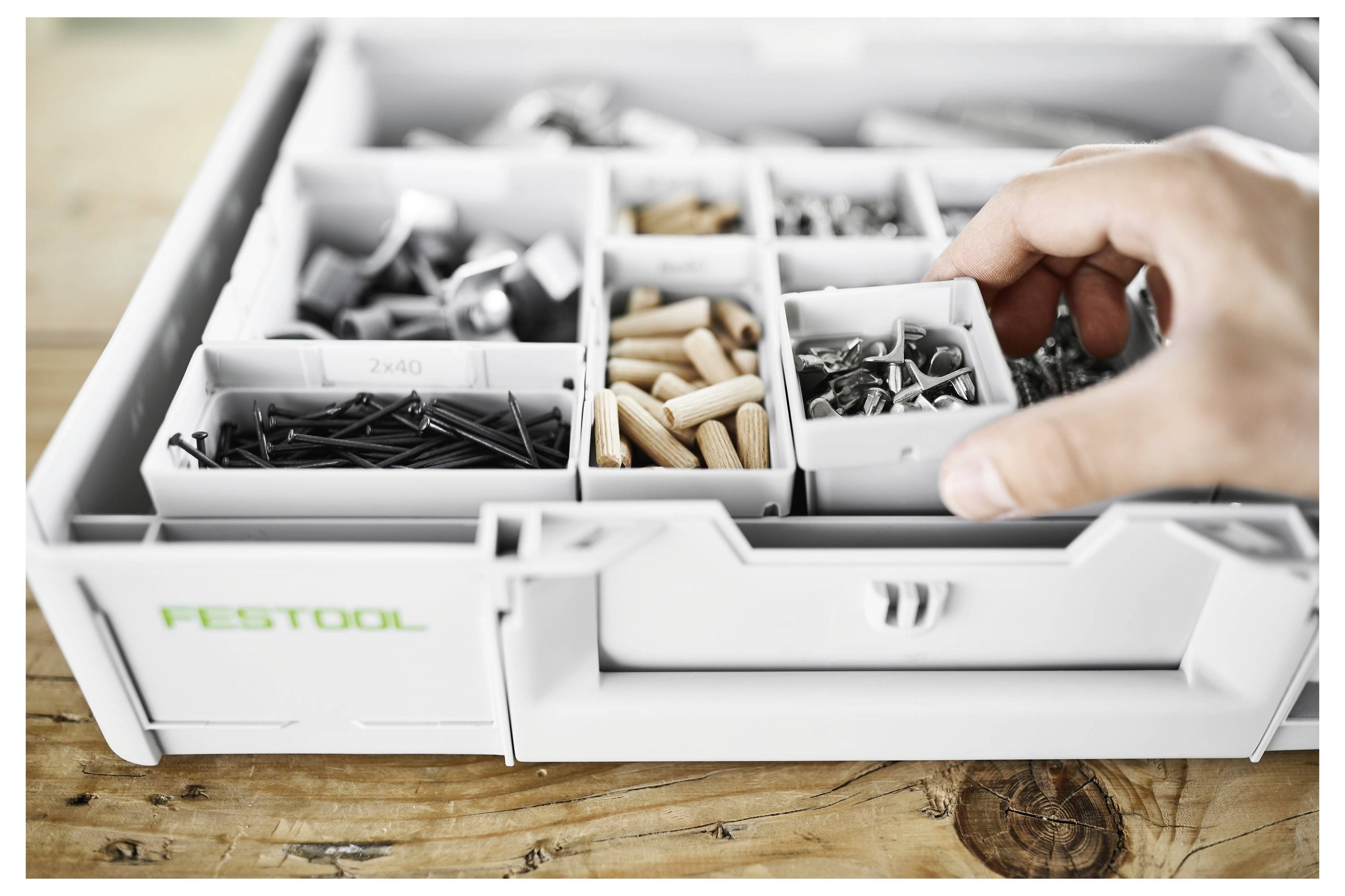 'Persona che regola una levigatrice in una stanza in costruzione, con pareti sullo sfondo prive di vernice e finitura.'