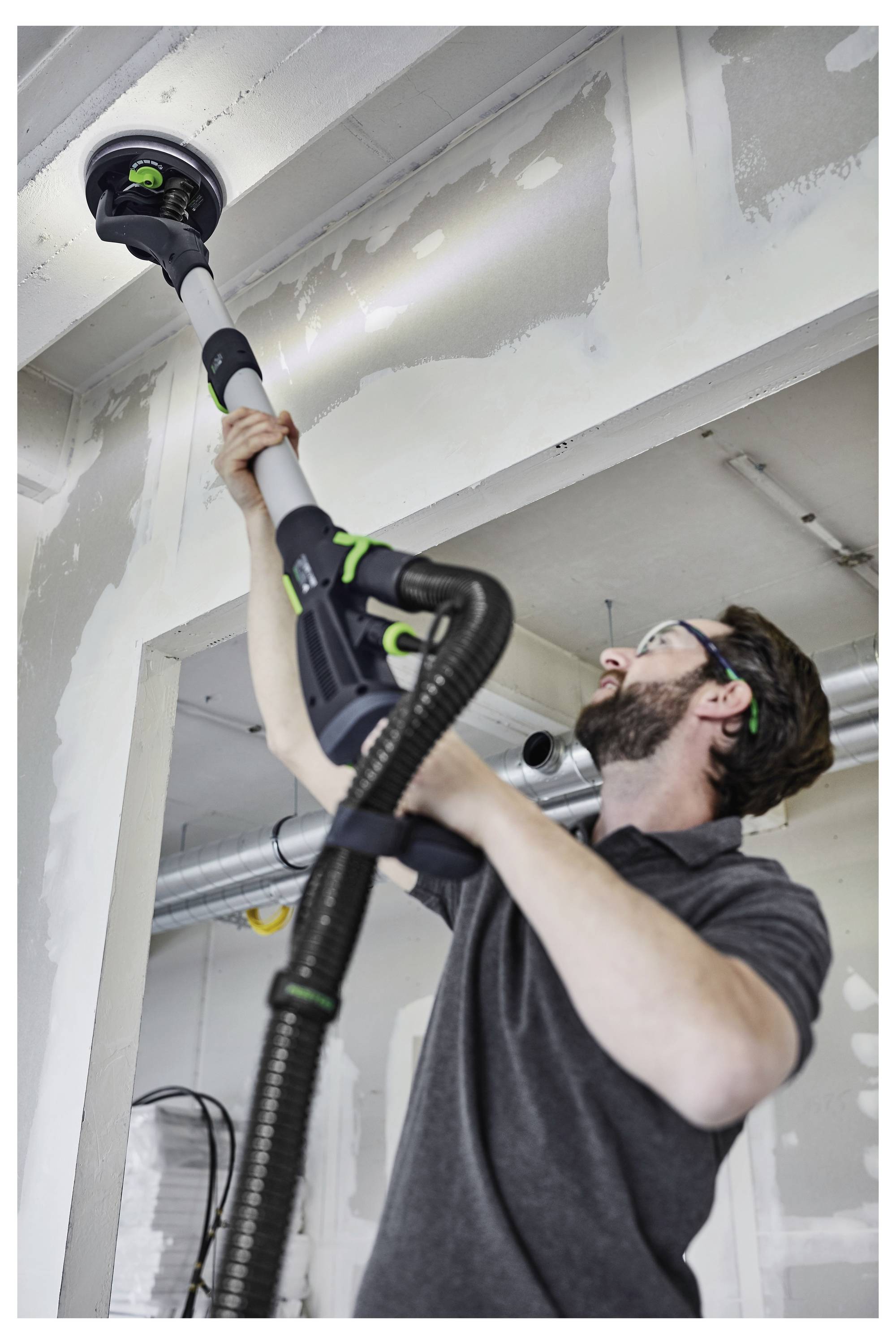 Una mano regola un componente della macchina in un laboratorio, concentrandosi sulla leva e sulle parti metalliche.