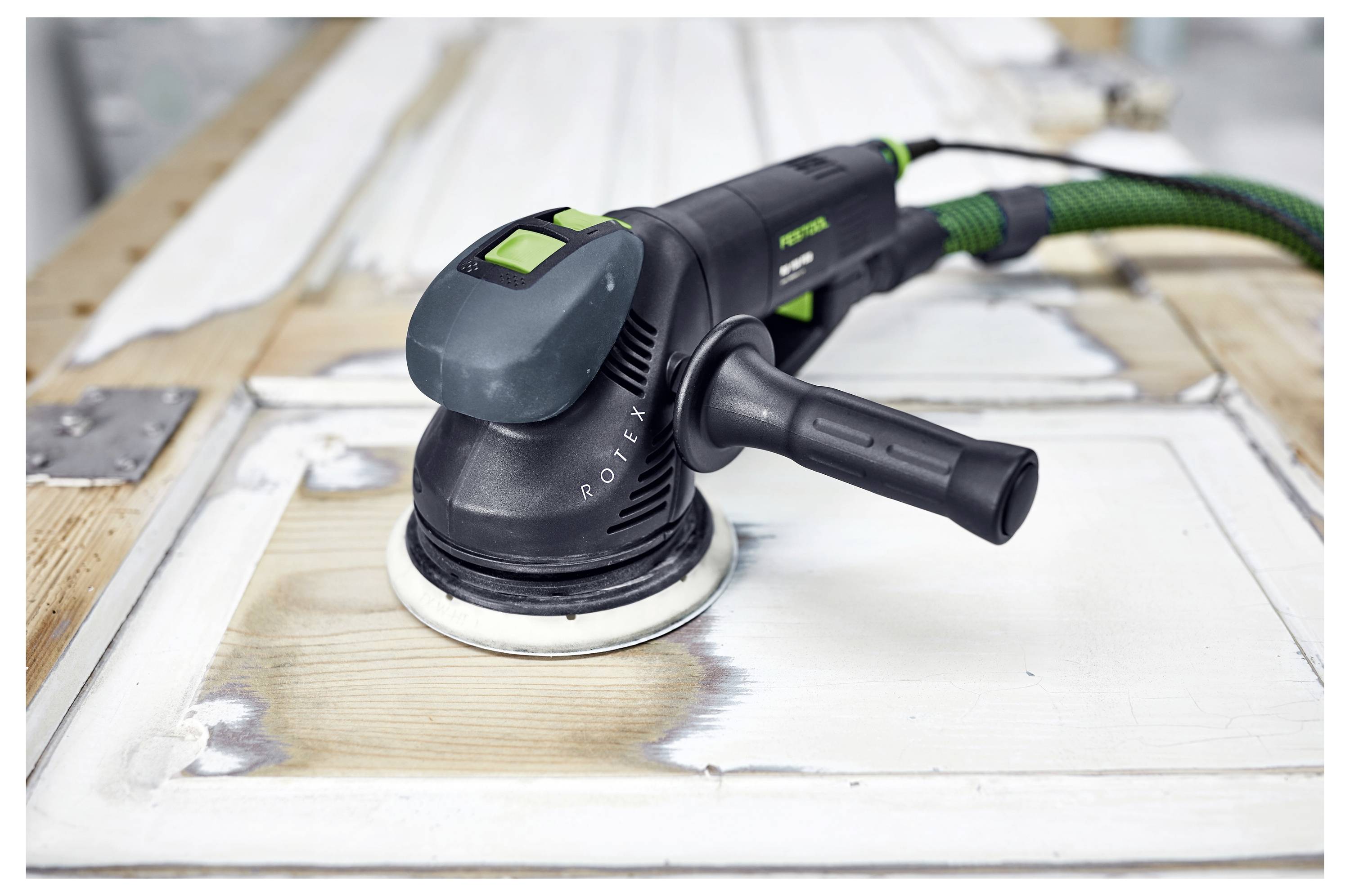 Una levigatrice elettrica che liscia la superficie di una porta di legno, evidenziando le aree risistemate.