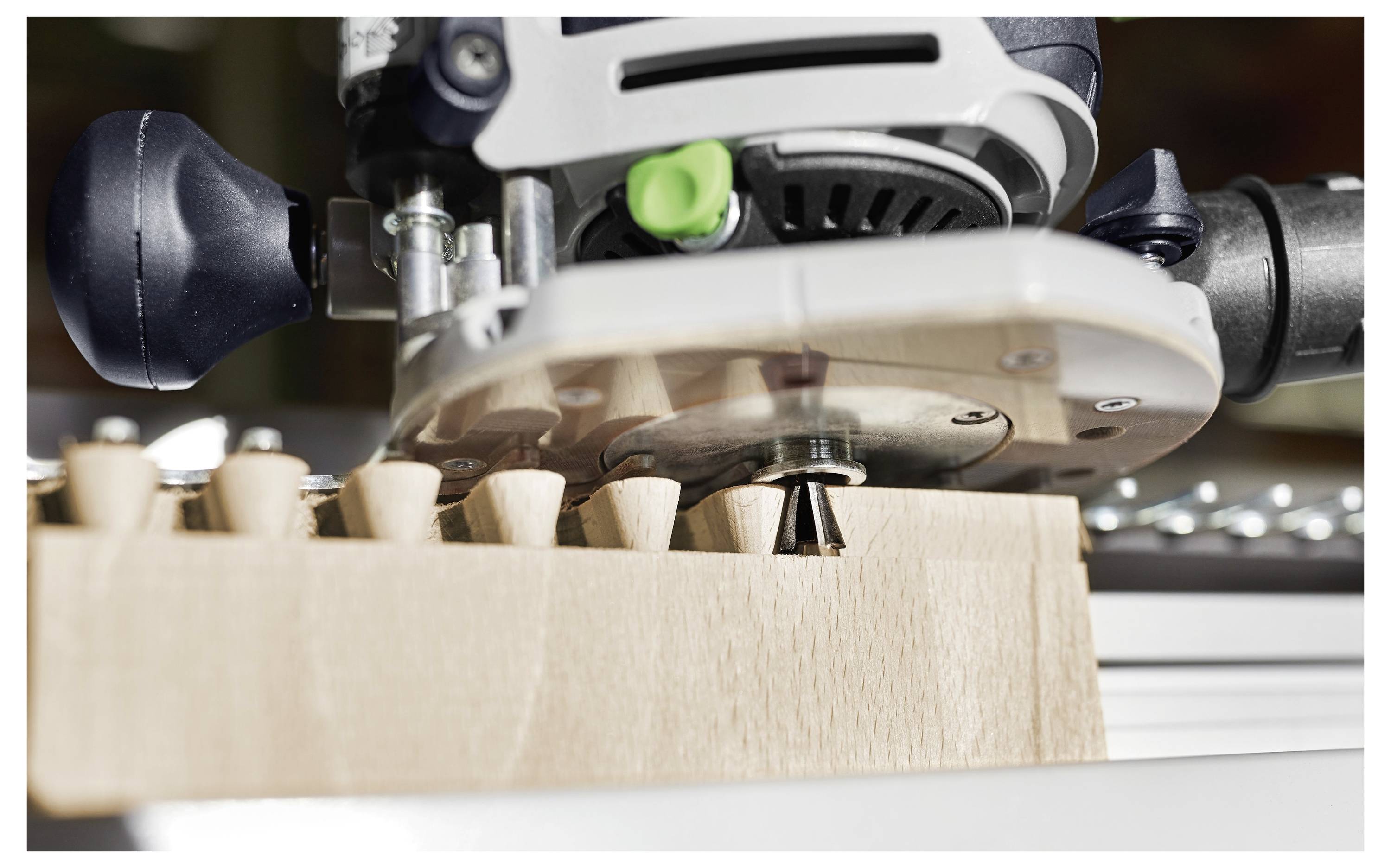 Un primo piano di uno strumento per la lavorazione del legno che taglia giunti a coda di rondine precisi in un pezzo di legno, dimostrando l'artigianalità dettagliata e la precisione.