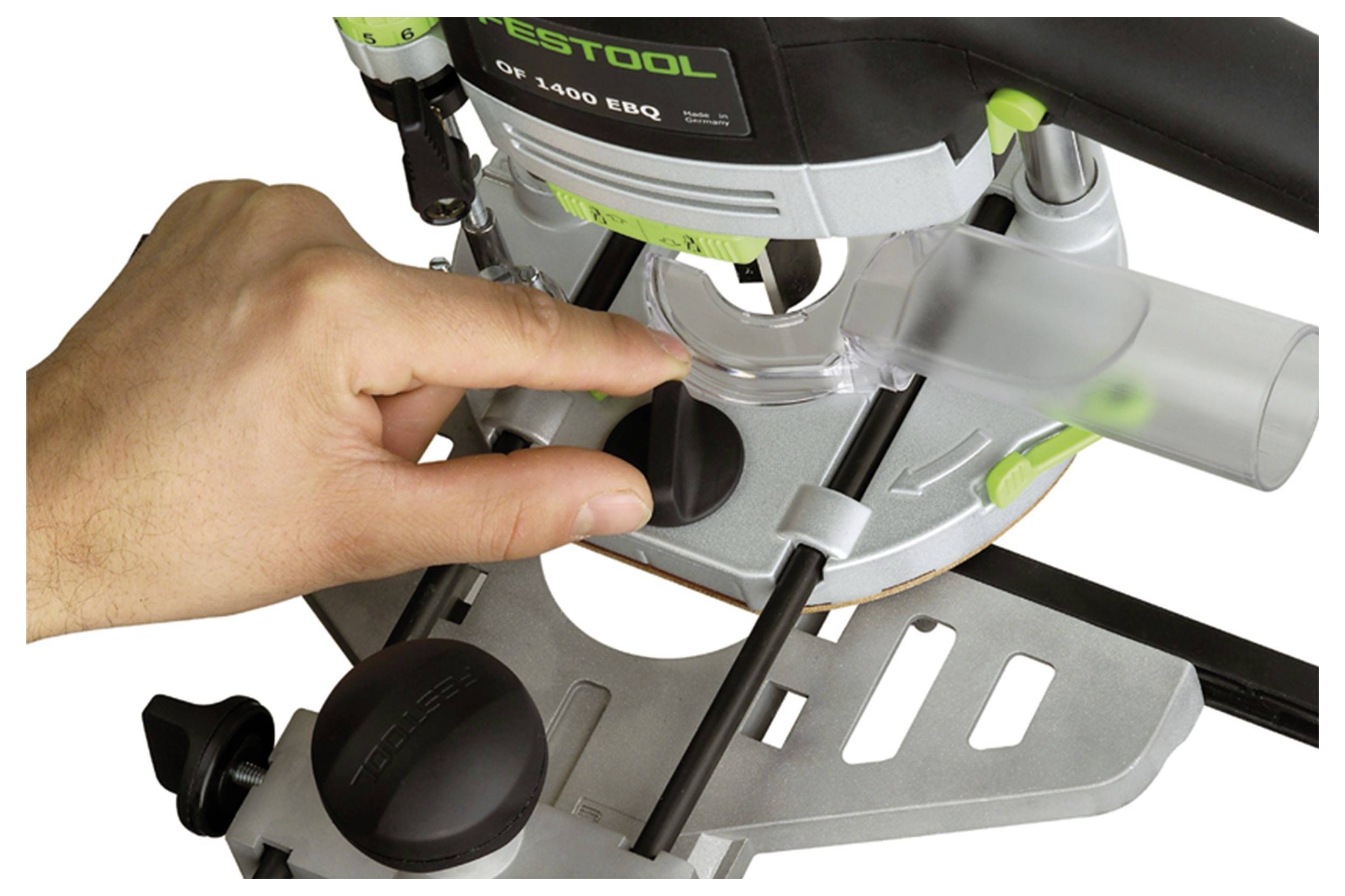 Una mano regola il fermastop della profondità di un router Festool, mettendo in evidenza le caratteristiche di controllo di precisione per i lavori di falegnameria.