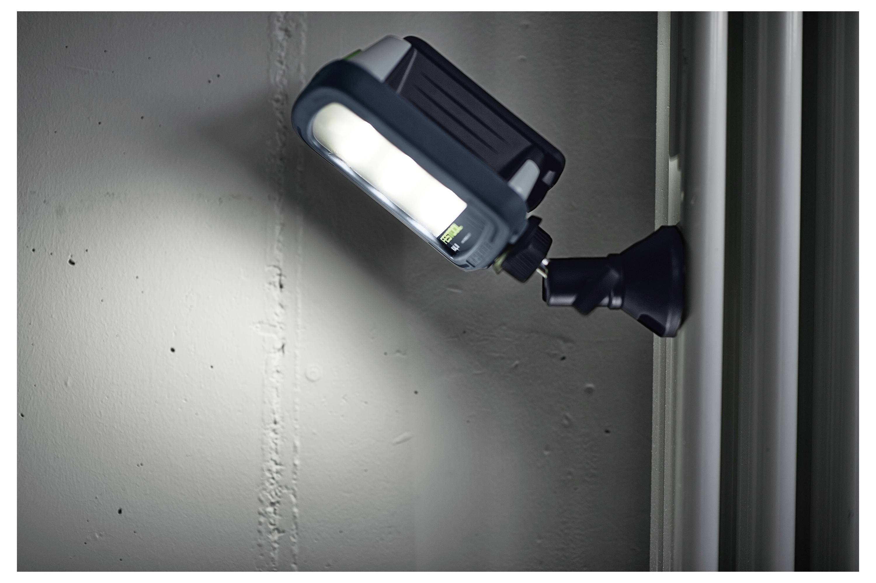 Un dispositivo di illuminazione LED montato a parete, illuminato, che brilla su una superficie vicina in un ambiente interno, evidenziando il suo braccio regolabile.