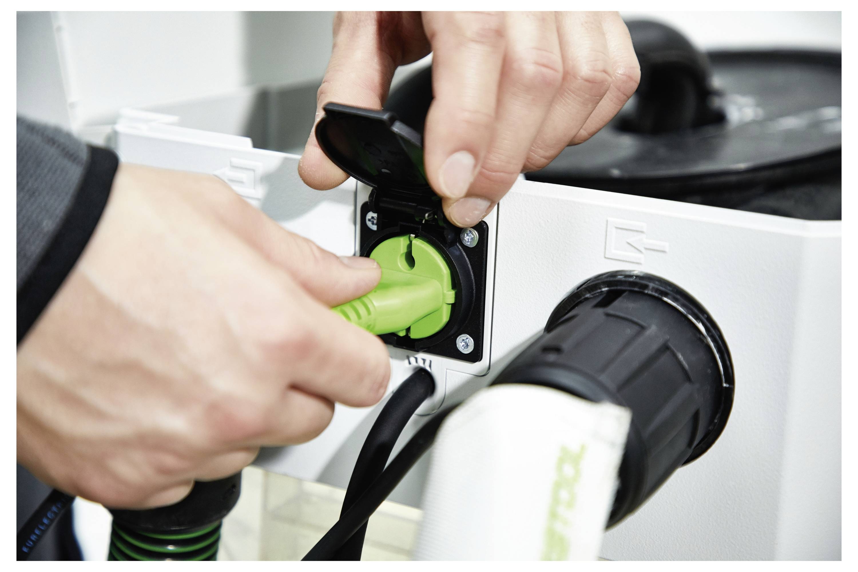 'Persona che utilizza una smerigliatrice da soffitto in una stanza parzialmente finita, con pannelli di soffitto aperti e una grande finestra sullo sfondo.'