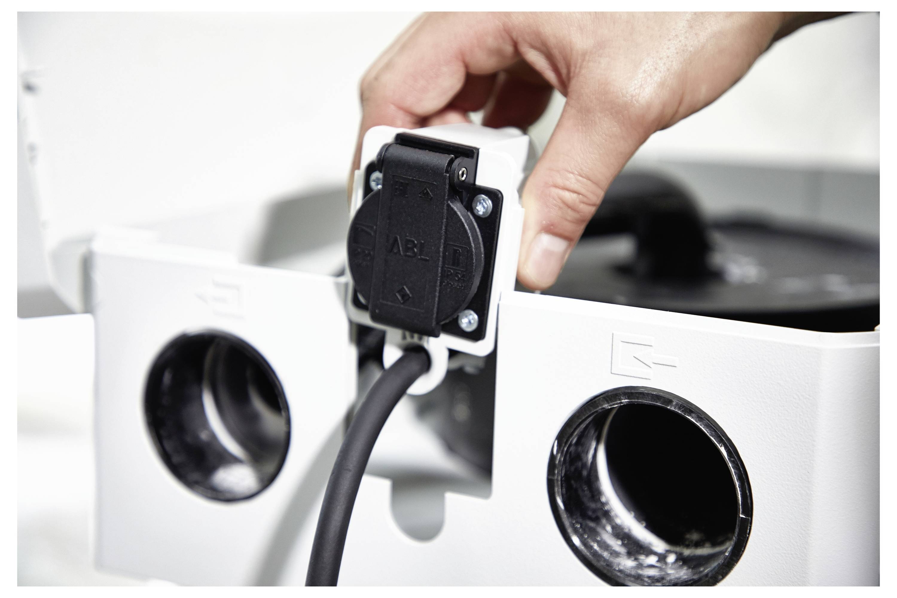 'Persona in maglietta grigia che usa un trapano senza fili in un laboratorio.'