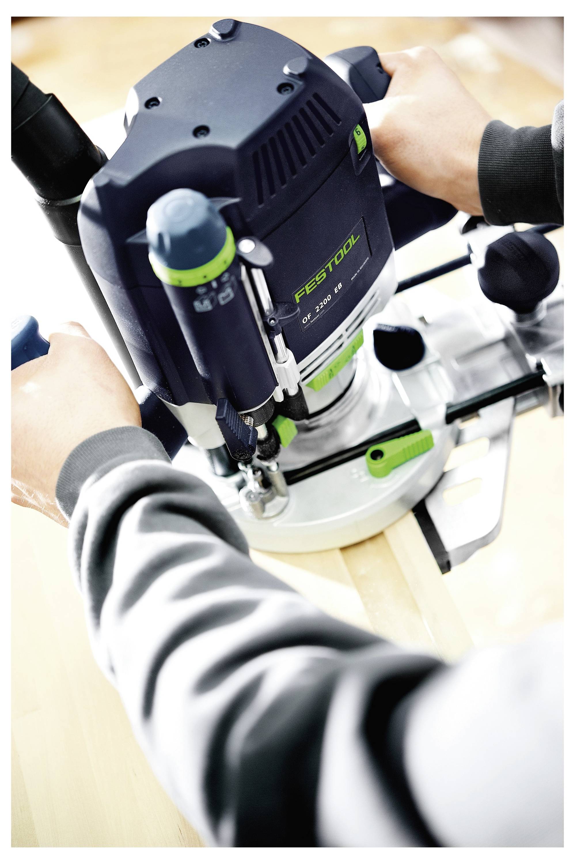 Una persona utilizza uno strumento di falegnameria di precisione per intagliare giunti a coda di rondine in una tavola di legno, dimostrando l'artigianalità dettagliata.