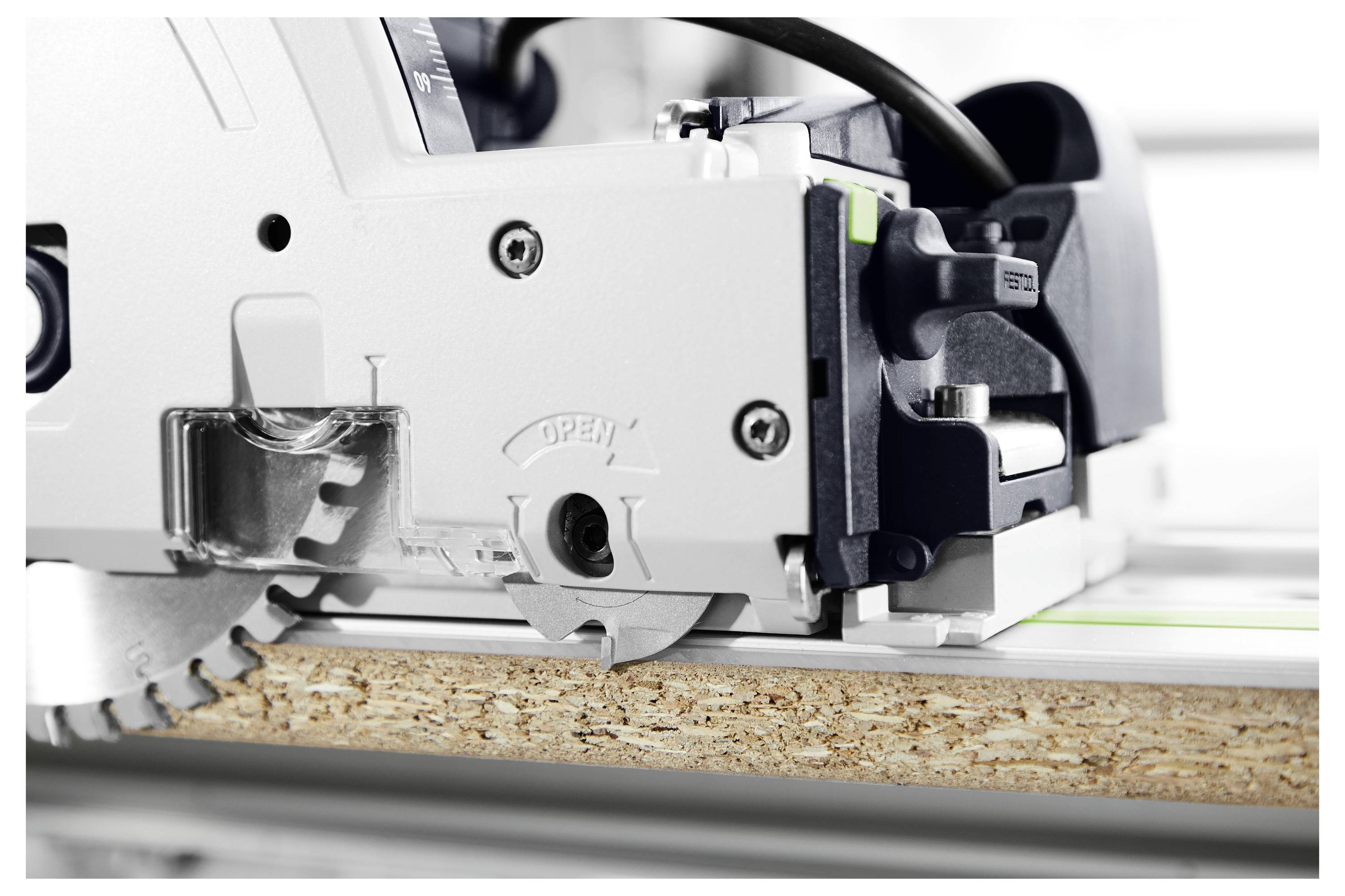 Una sega circolare che taglia attraverso un pezzo di legno, mostrando i dettagli della lama e del macchinario; il bordo del legno è visibile sotto la sega.