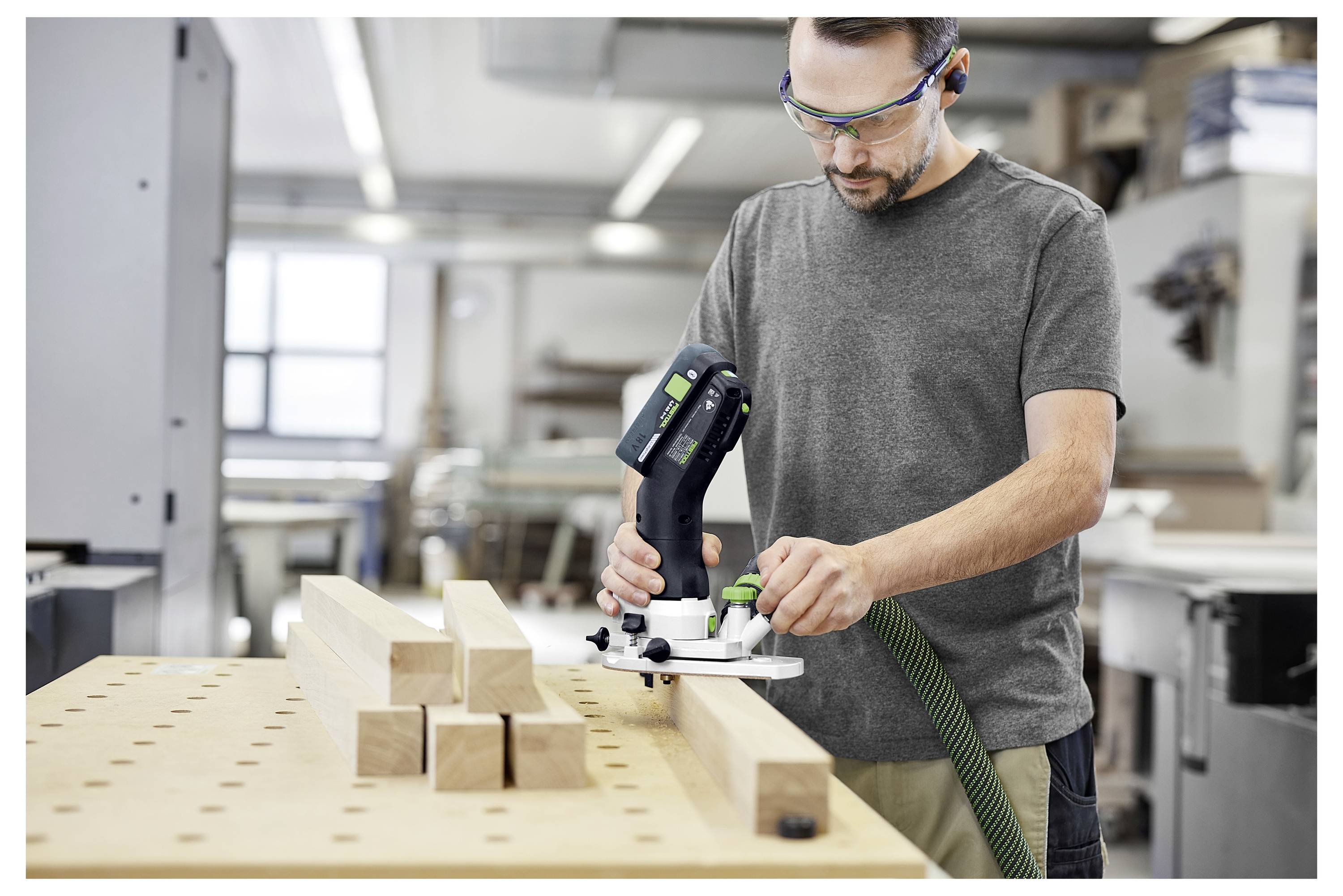 Una persona assembla un set di attrezzi a un tavolo, selezionando un accessorio da una custodia aperta piena di vari bit per cacciaviti e attrezzi manuali.