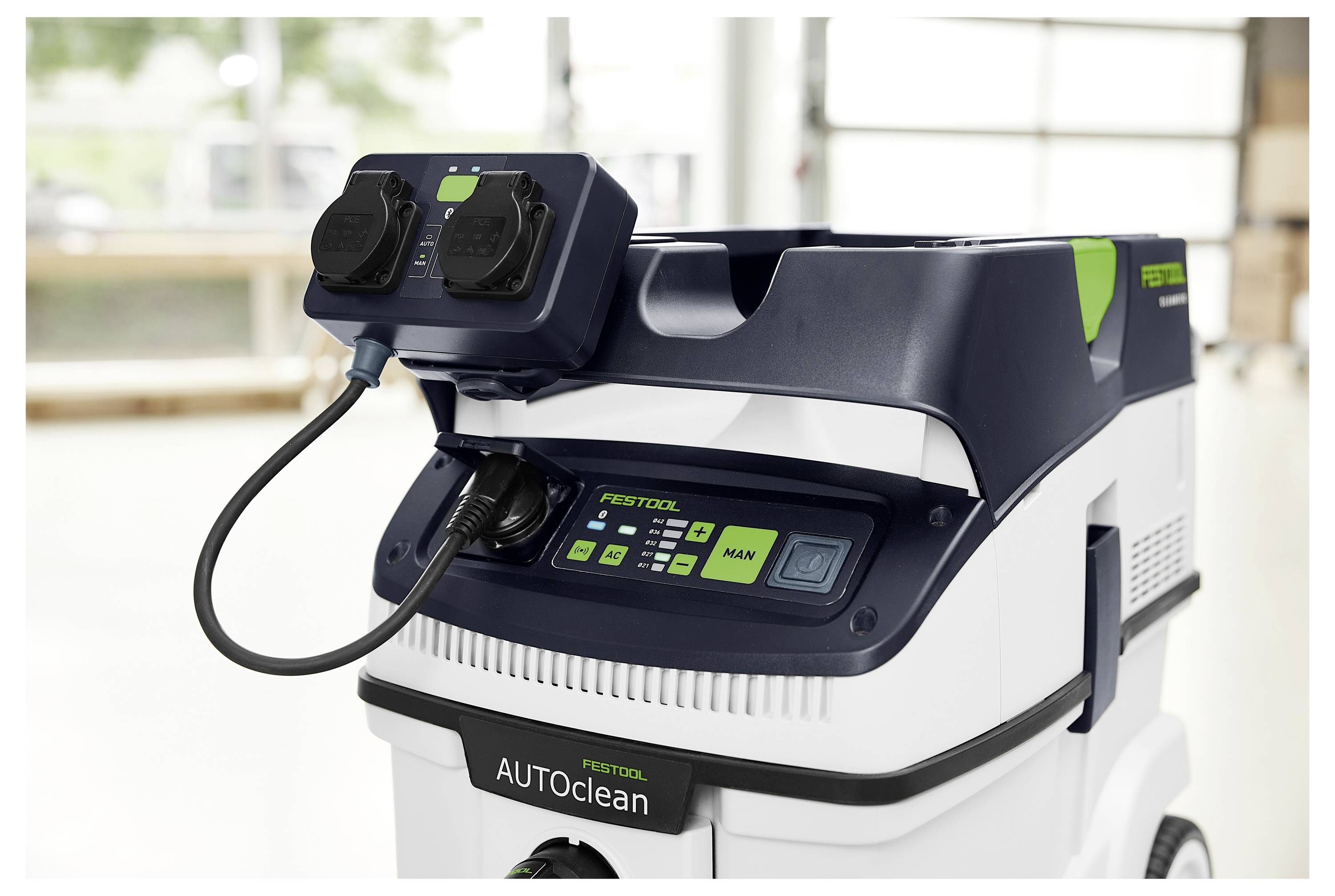 Una persona che utilizza un trapano senza fili per avvitare una vite in una superficie in un cantiere. La persona indossa occhiali di sicurezza.