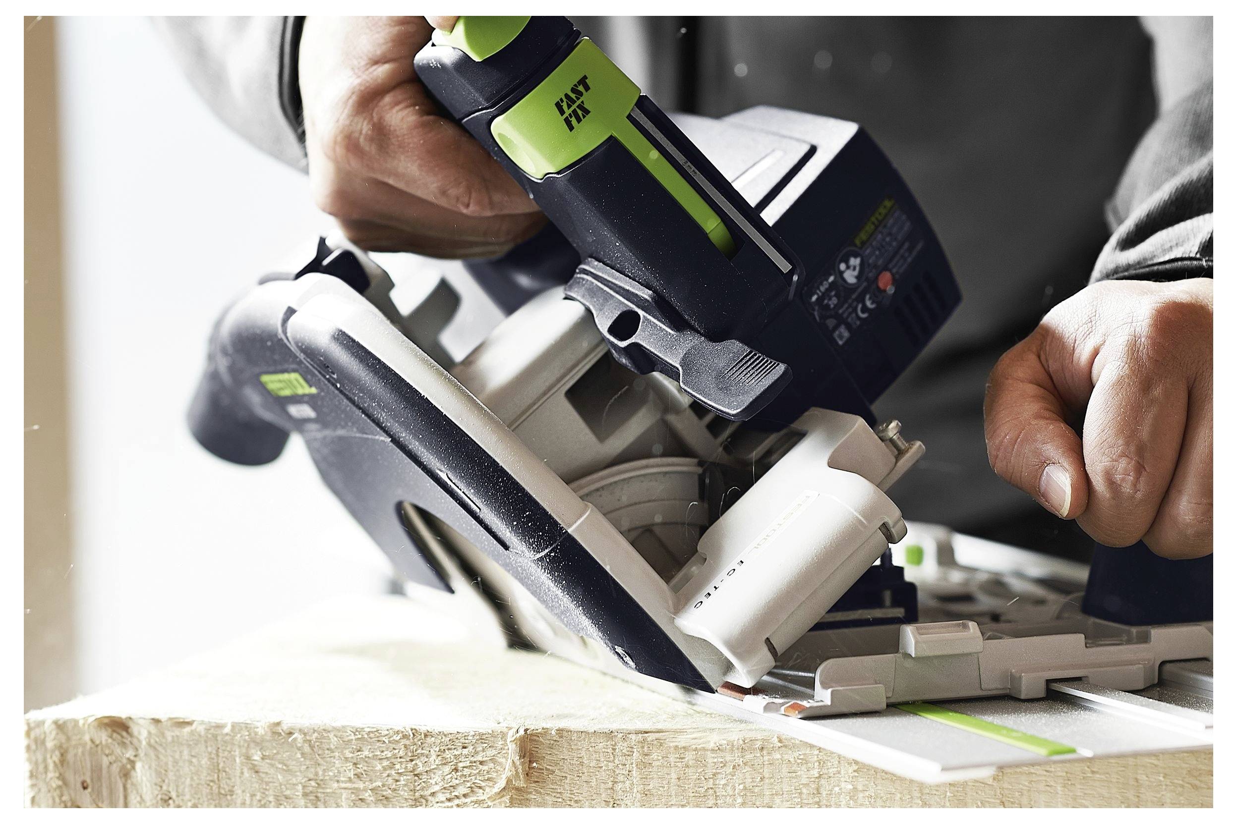 Una persona utilizza una sega circolare per tagliare una tavola di legno, concentrandosi sulla precisione e sul funzionamento dell'attrezzo in un ambiente di laboratorio.