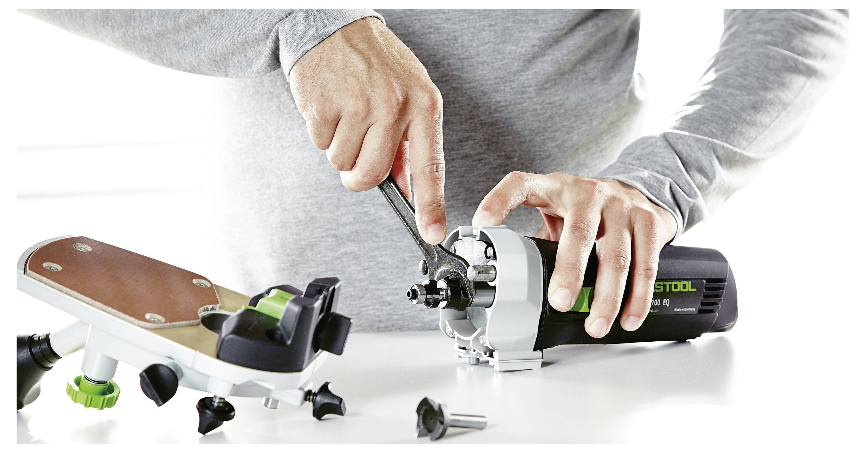 Un aspirapolvere in una sala pulita con una persona che usa un accessorio tubo per pulire il pavimento.