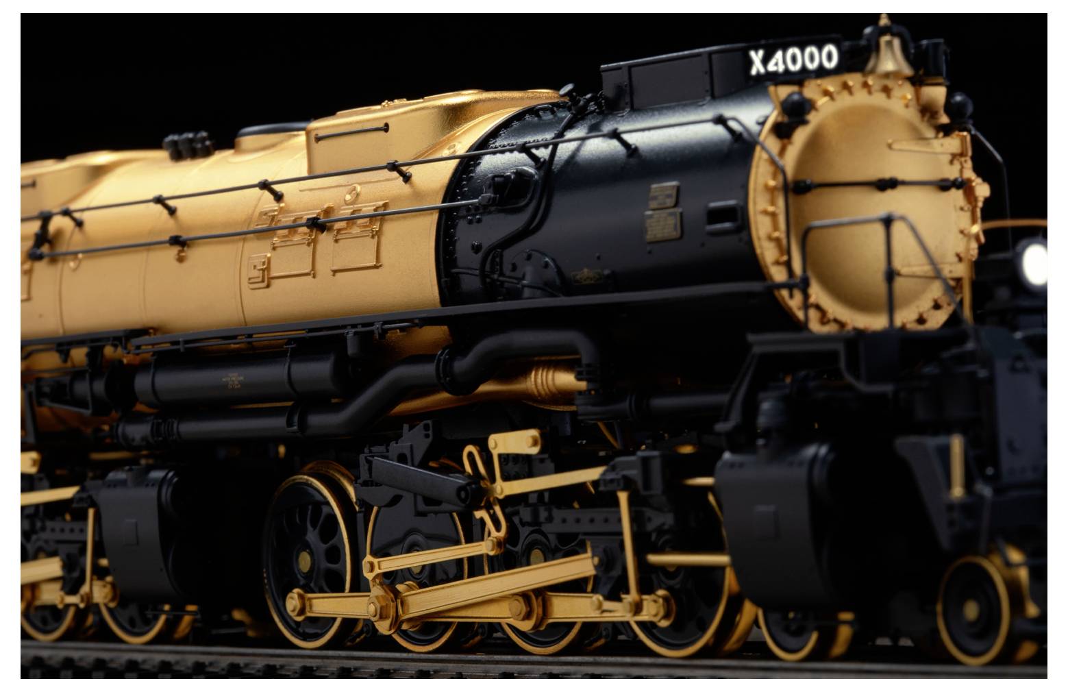 Un modello di un treno d'epoca che mostra caratteristiche dettagliate come fanali, finestre e ringhiere protettive su un binario.