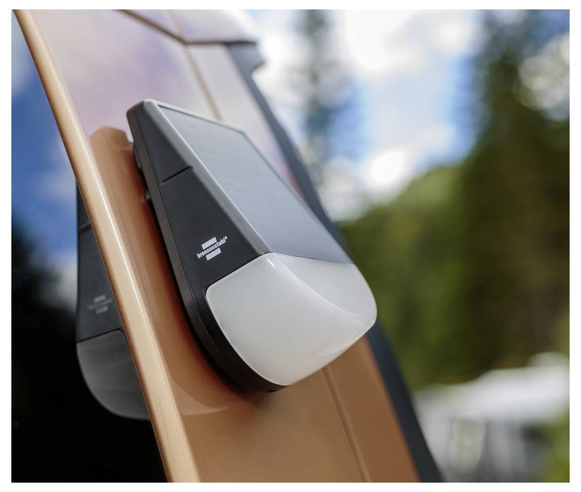 Una luce per auto alimentata a energia solare montata sull'esterno di un veicolo con uno sfondo di alberi e cielo, indicando l'uso di tecnologia ecologica.