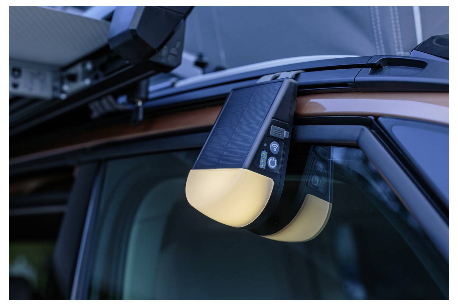 Un dispositivo montato su un portapacchi sul tetto di un veicolo, dotato di pulsanti e una luce, probabilmente utilizzato per illuminazione o segnalazione.