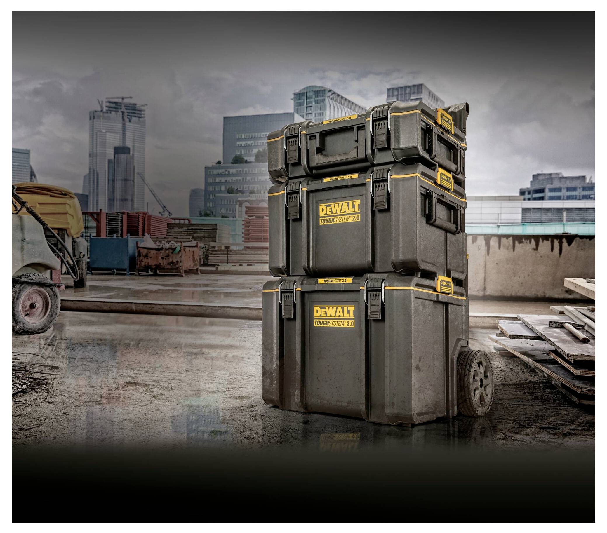 Cassette degli attrezzi DEWALT impilate in un cantiere con lo skyline della città sullo sfondo, evidenziando l'immagazzinamento e la mobilità.
