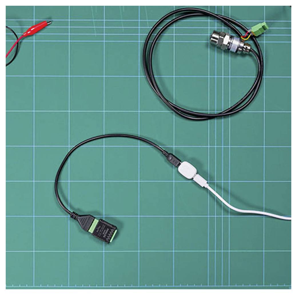 Un tappetino a griglia verde con cavi, connettori e un sensore posizionato sopra. Il tappetino viene utilizzato per organizzare e assemblare componenti elettronici.