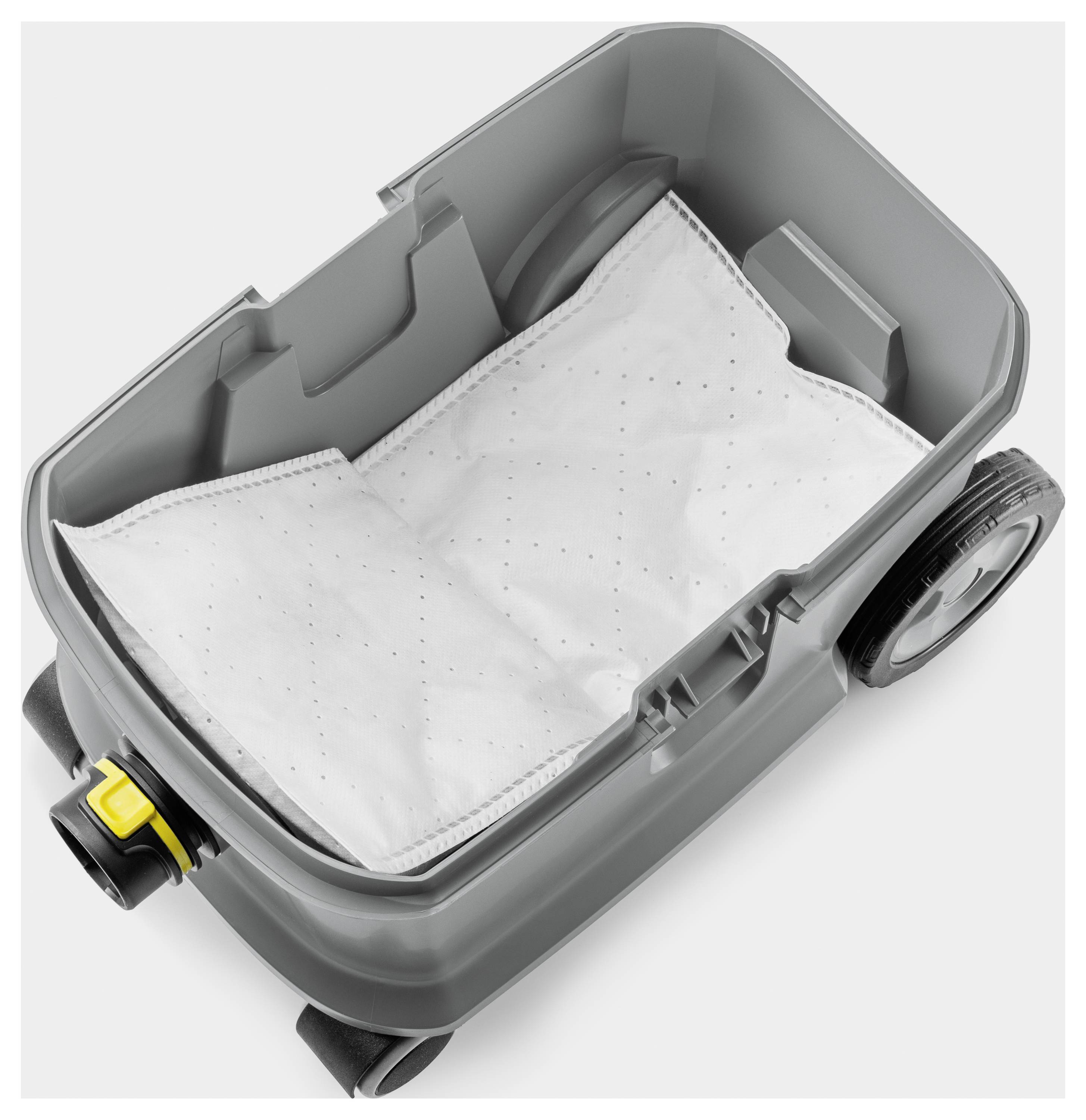 Un interno grigio dell'aspirapolvere con un filtro bianco o un sacchetto della polvere all'interno. Lo scomparto è aperto, mostrando la sua forma rettangolare e le ruote.