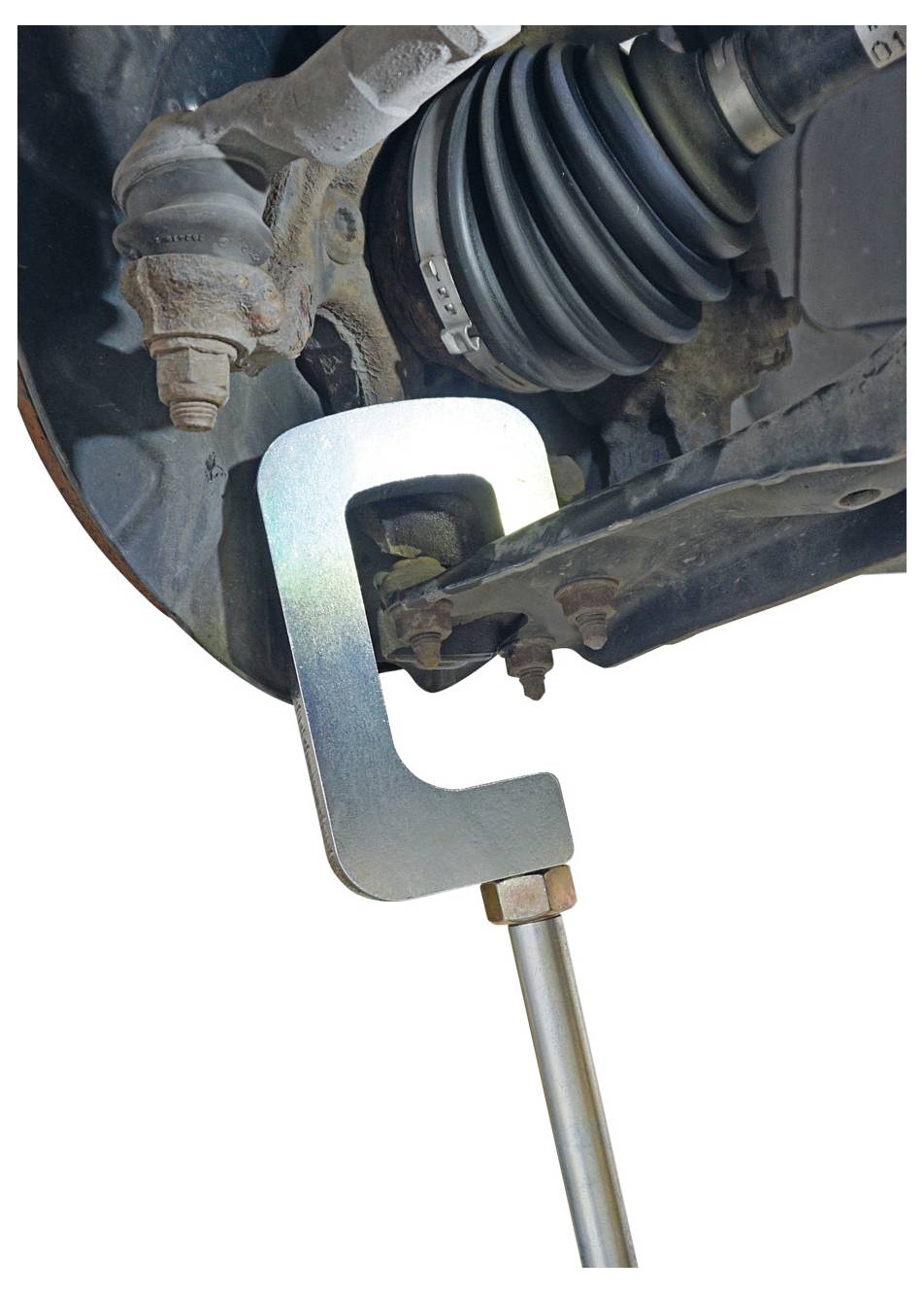 Uno strumento di serraggio viene applicato al sistema di sospensione di un'auto per la riparazione, mostrando un dettaglio ravvicinato dei componenti metallici e delle connessioni.
