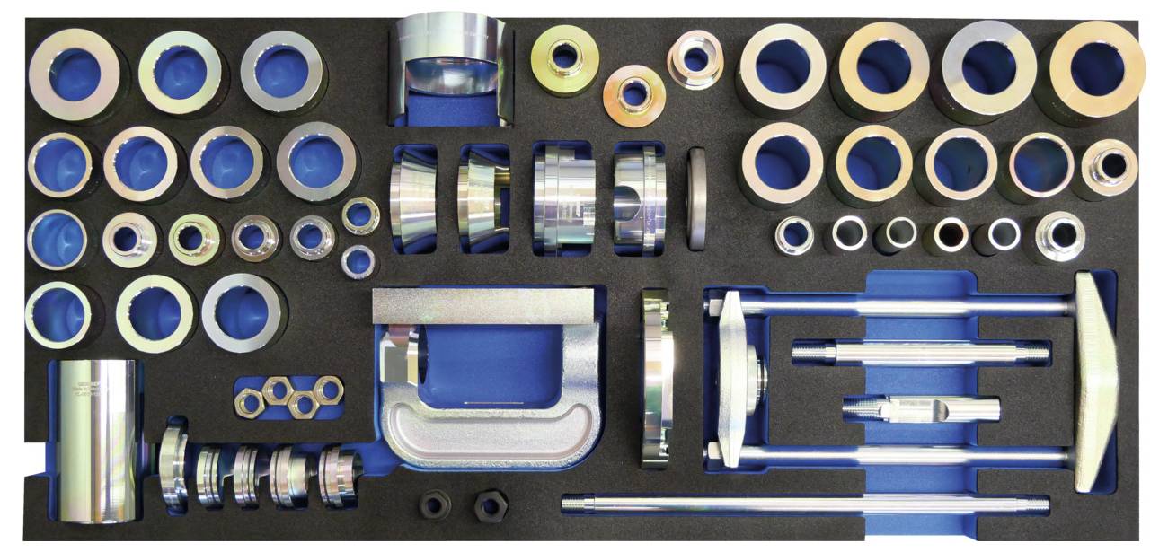 'Set di attrezzi automobilistici su sfondo blu, che presenta vari attacchi, chiavi fisse e una morsa a C, organizzati in un ritaglio di schiuma per un accesso facile.'