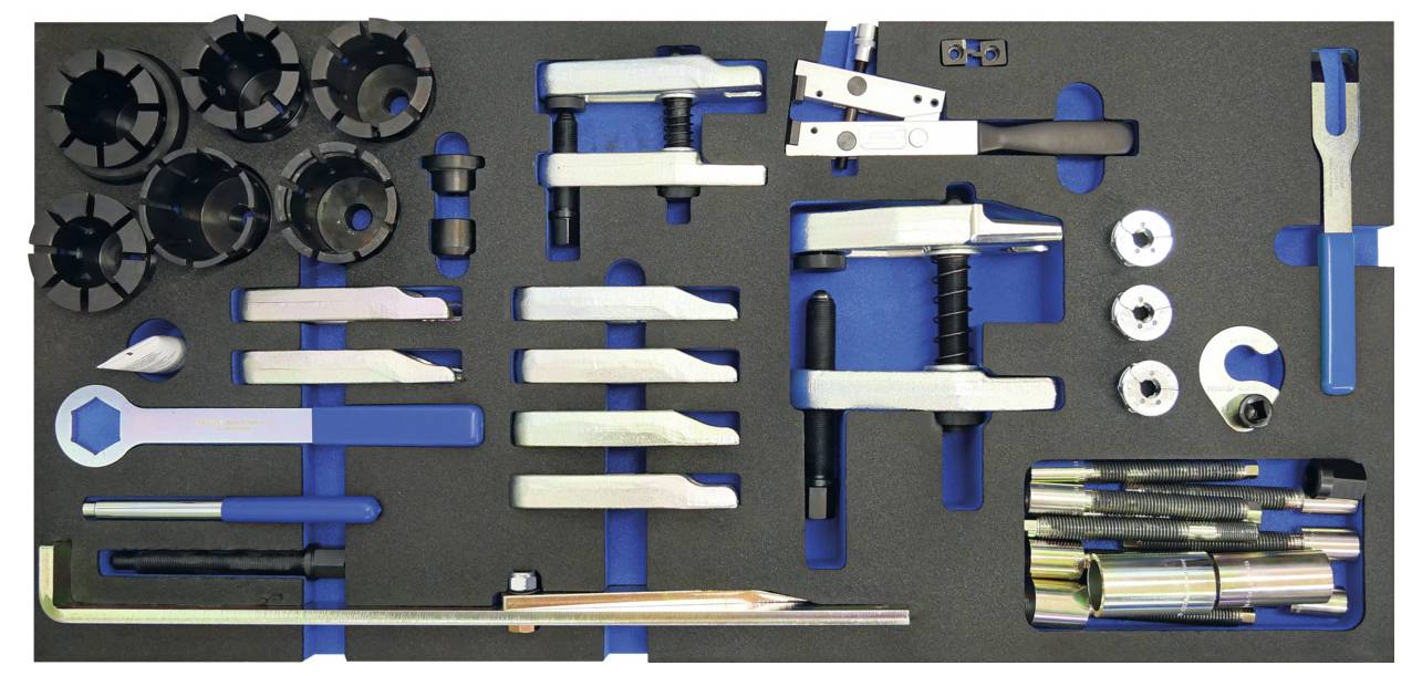 Una collezione di attrezzi meccanici organizzati e componenti, inclusi chiavi, bussole, viti e raccordi, disposti ordinatamente in tre sezioni.