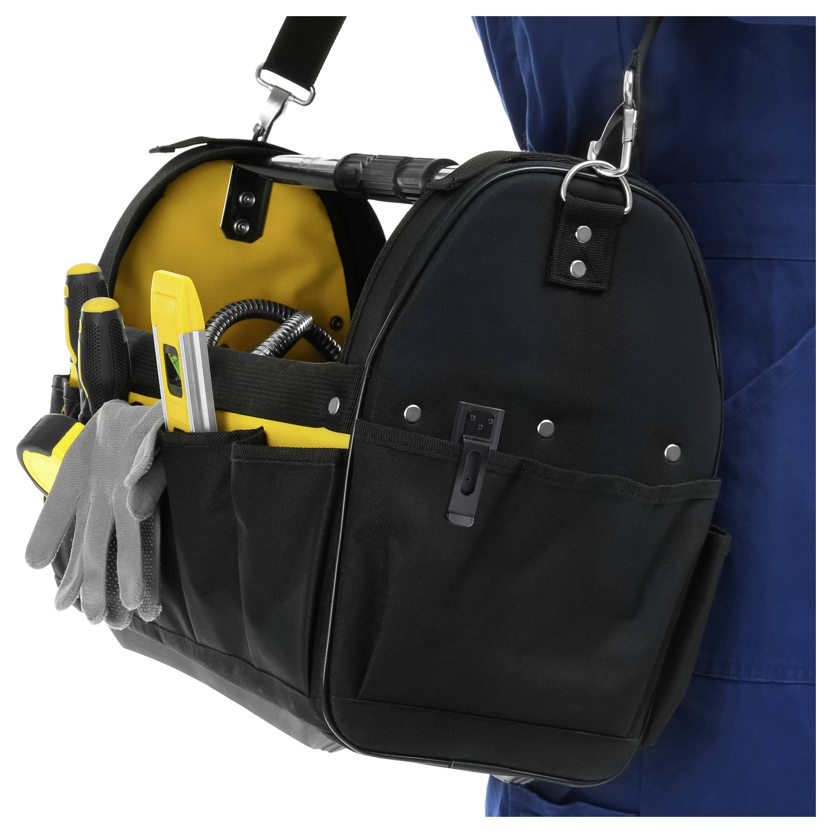 Borsa degli attrezzi con maniglie, guanti, un metro a nastro e una livella, trasportata da una persona in tuta da lavoro blu.