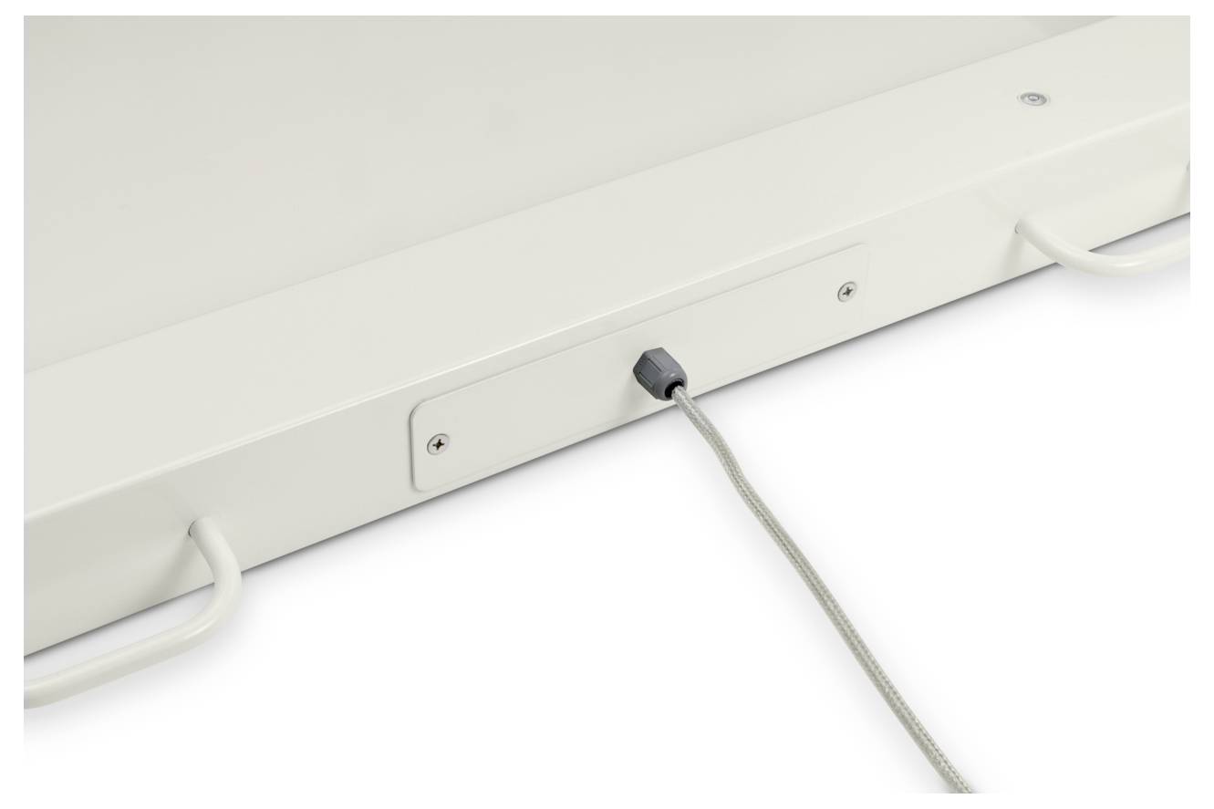 Un primo piano di una lavagna bianca con due maniglie metalliche e un cavo di ricarica grigio collegato a una porta sul suo lato.