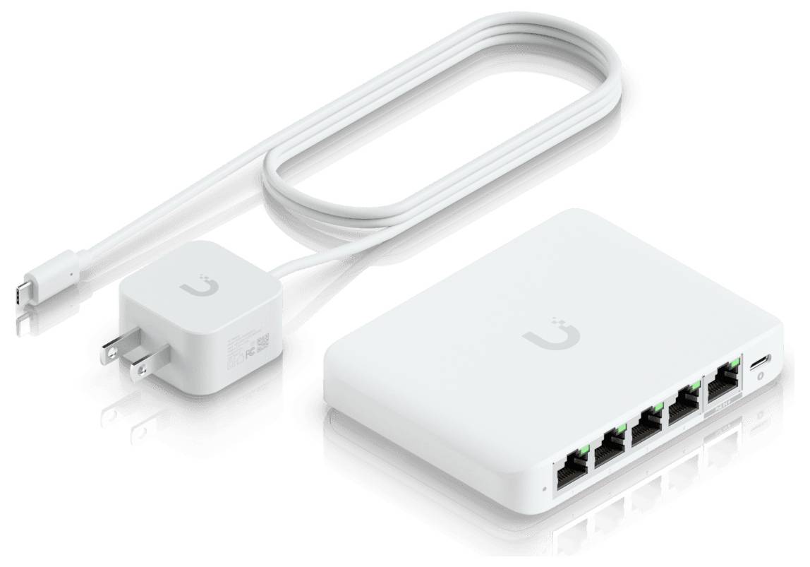 'Switch di rete bianco con cinque porte Ethernet, accompagnato da un adattatore di alimentazione e da un cavo, su uno sfondo bianco.'