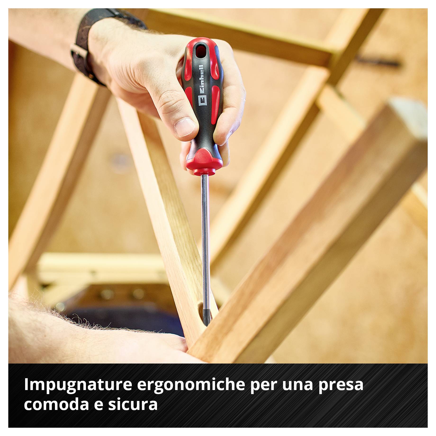 Mano con cacciavite mentre lavora su una struttura in legno; in basso è scritto: 'Le impugnature ergonomiche offrono un maneggio confortevole e una presa sicura'