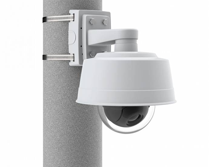 Una telecamera di sicurezza montata su un palo, racchiusa in un involucro protettivo bianco, progettata per la sorveglianza esterna.