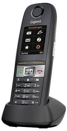 Telefono cordless Gigaset nero su base di ricarica che mostra lo schermo del menu in tedesco. Presenta tastiera con pulsanti numerici e funzione.
