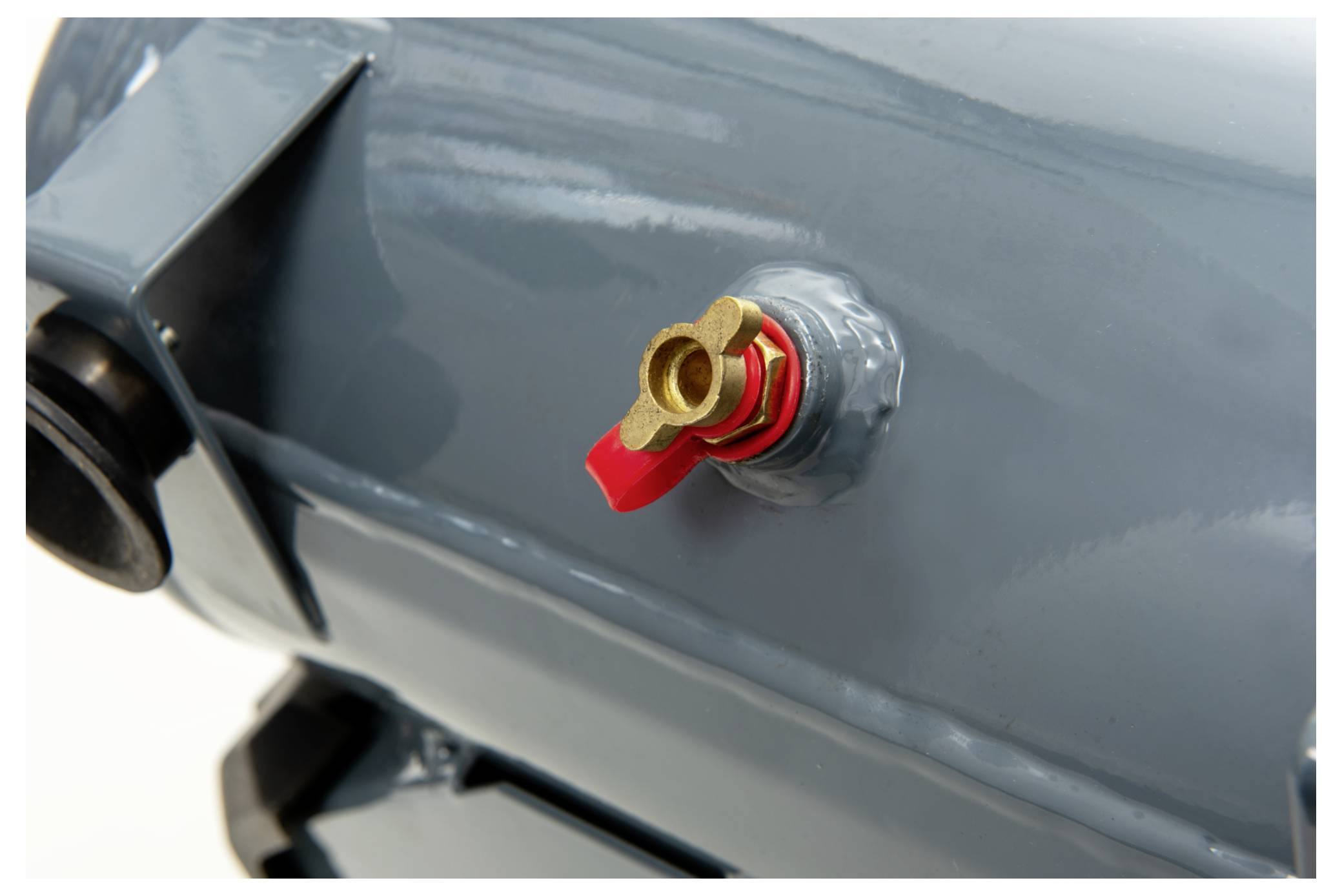 Un'immagine ravvicinata di un serbatoio d'aria compressa in argento con una valvola in metallo rosso. La valvola è montata sulla superficie del serbatoio.