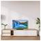 Una moderna sala da pranzo con una TV a schermo piatto su un mobile in legno. La TV mostra un'immagine vivida di un paesaggio con un lago di montagna.