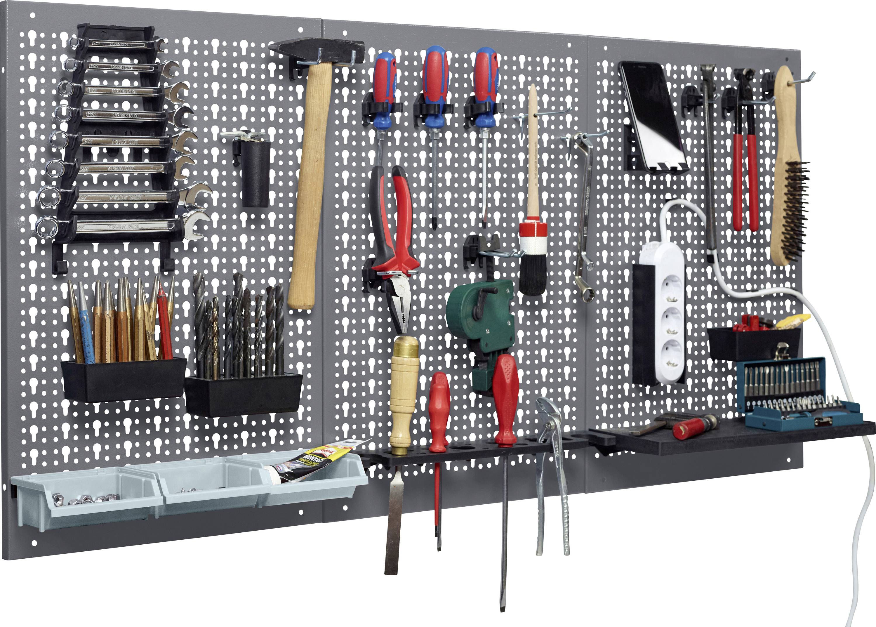 Una pegboard montata a parete contiene vari attrezzi tra cui cacciaviti, chiavi inglesi, un martello, un trapano, pinze e una prolunga, organizzati ordinatamente.