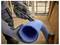 Una persona che indossa guanti utilizza un coltello Stanley a lama retrattile per tagliare un tubo di plastica corrugata blu, probabilmente parte di un'attività di costruzione o idraulica.