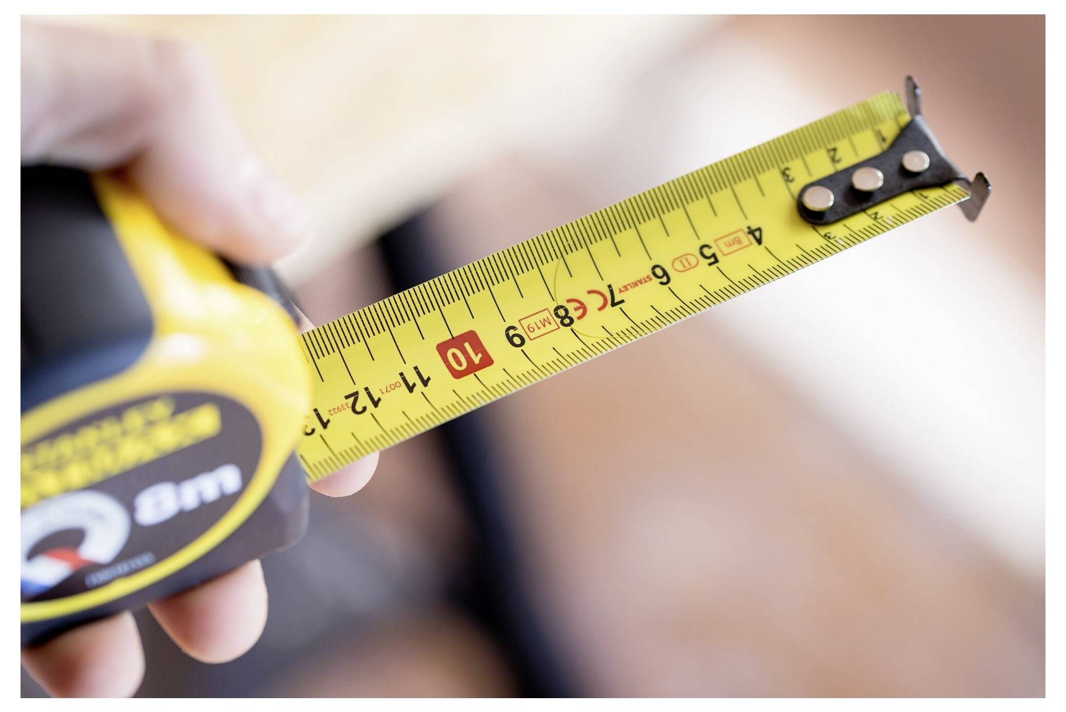 Due mani guantate che tengono una batteria gialla e grigia etichettata "Stanley Fatmax V20 2.0Ah Batteria al Litio".