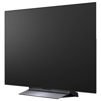 Televisore a schermo piatto di grandi dimensioni con schermo nero vuoto su un supporto, visto da un'angolazione su uno sfondo bianco.